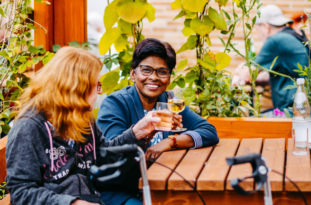 Zwei Damen sitzen in der Entdeckerlounge, eine Dame lächelt in die Kamera