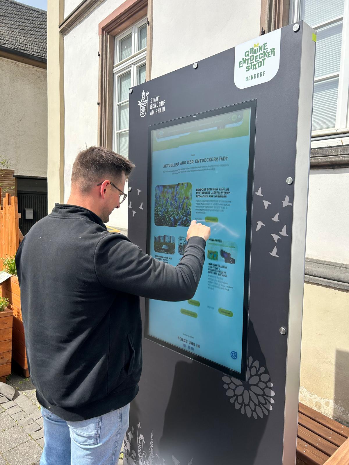 Mann steht vor der digitalen Stele