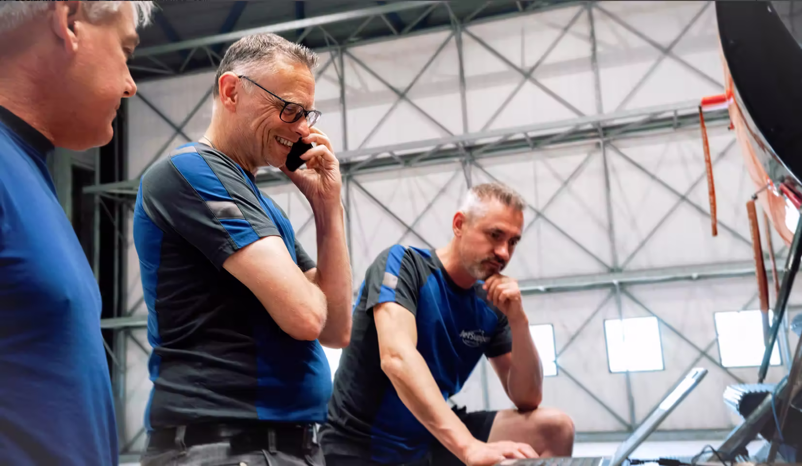Two colleagues coordinating work, one on the phone