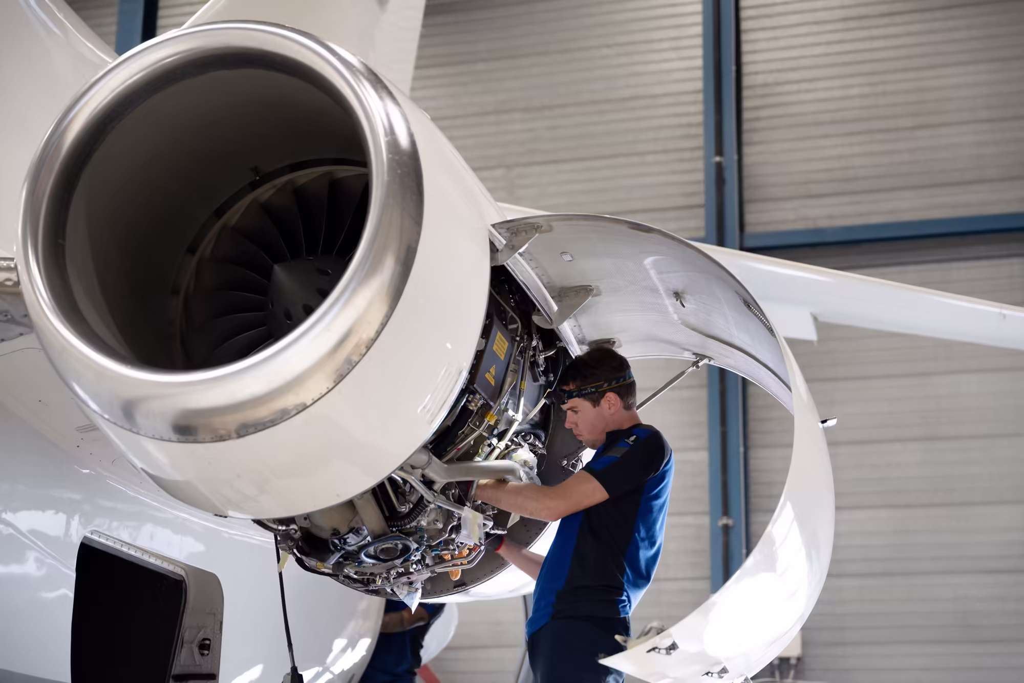 Technician working inside an opened engine cowling