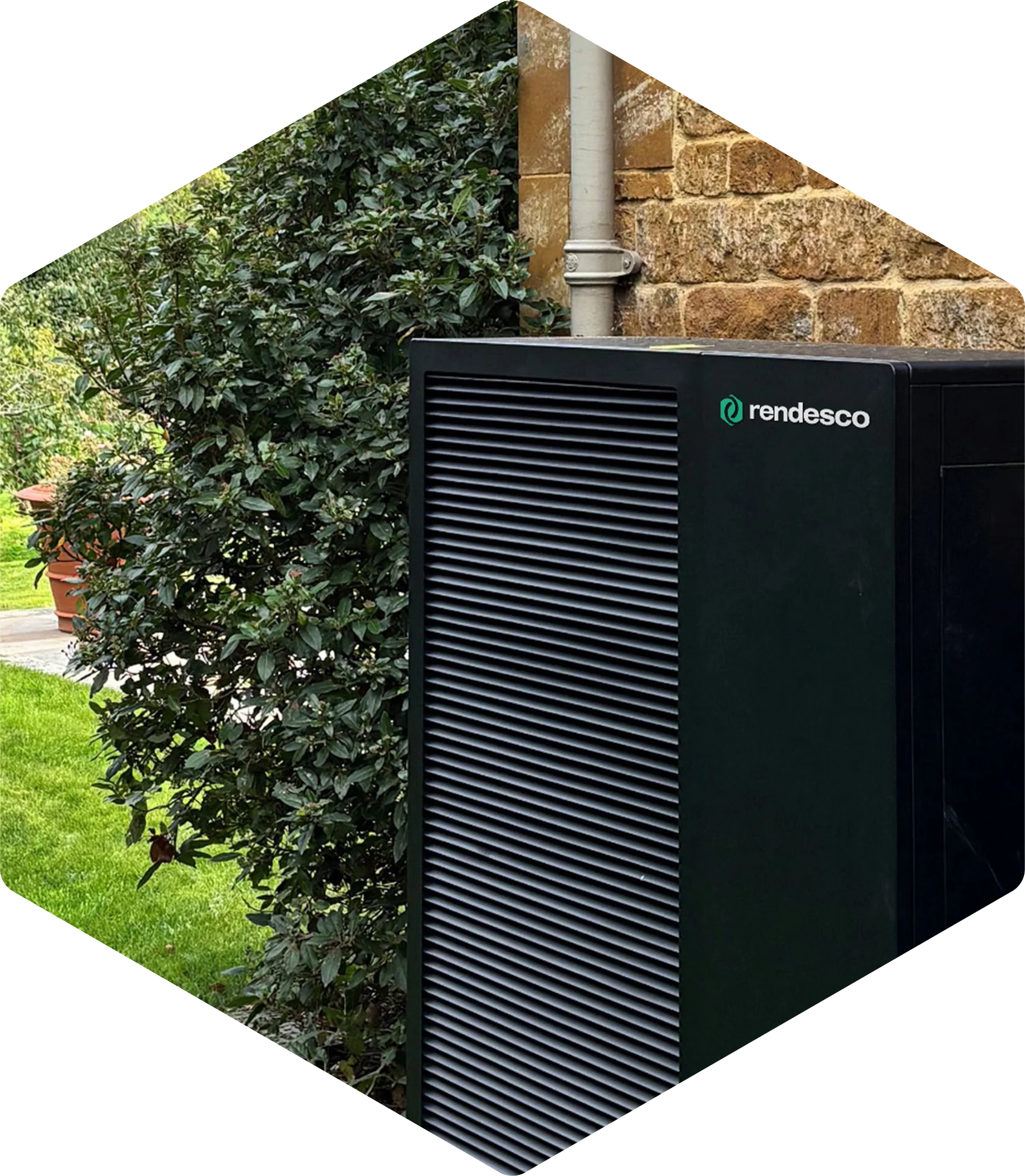 Modern heat pump unit installed outside with lush green plants