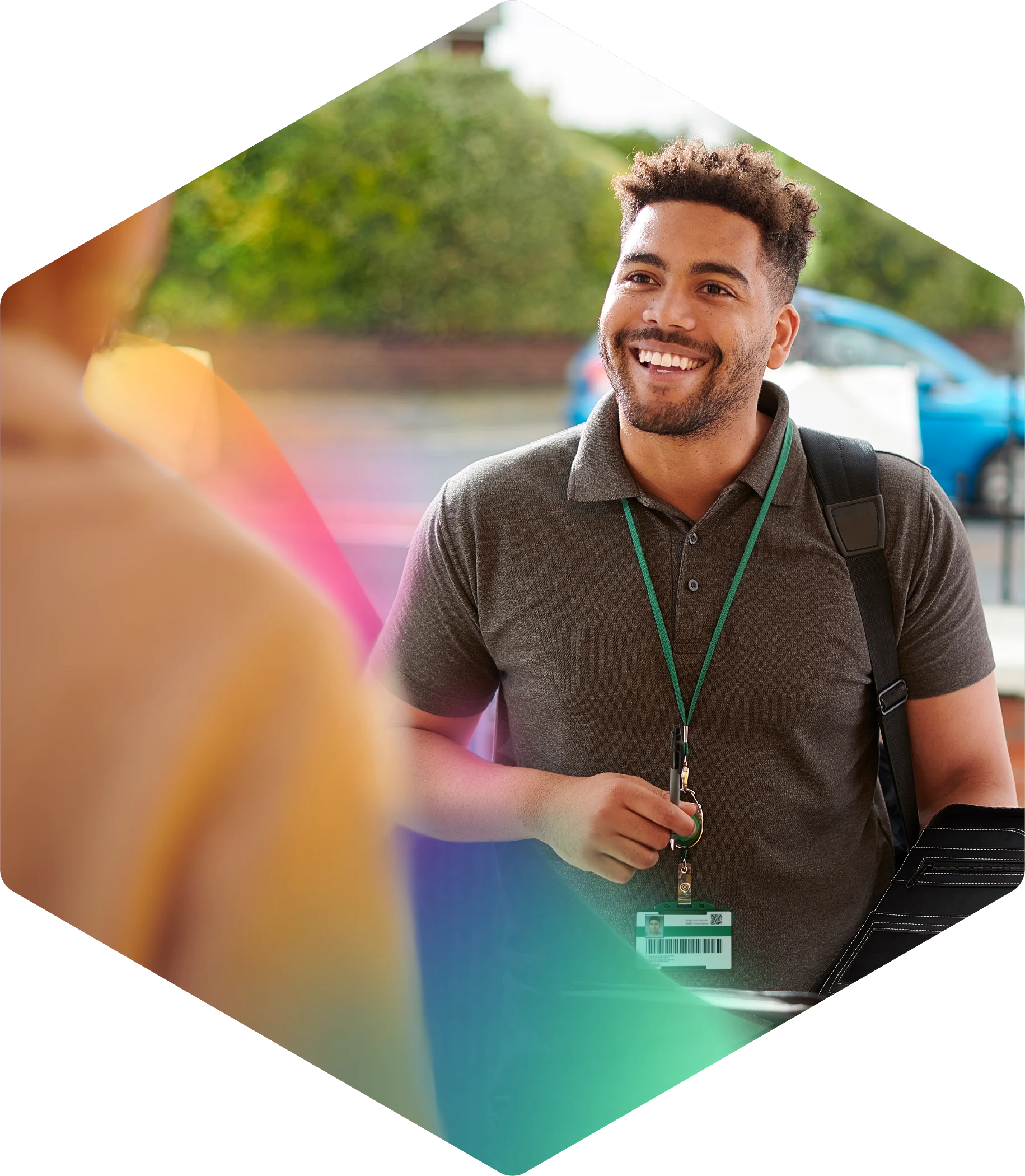 Smiling professional with lanyard standing outdoors with blurred background