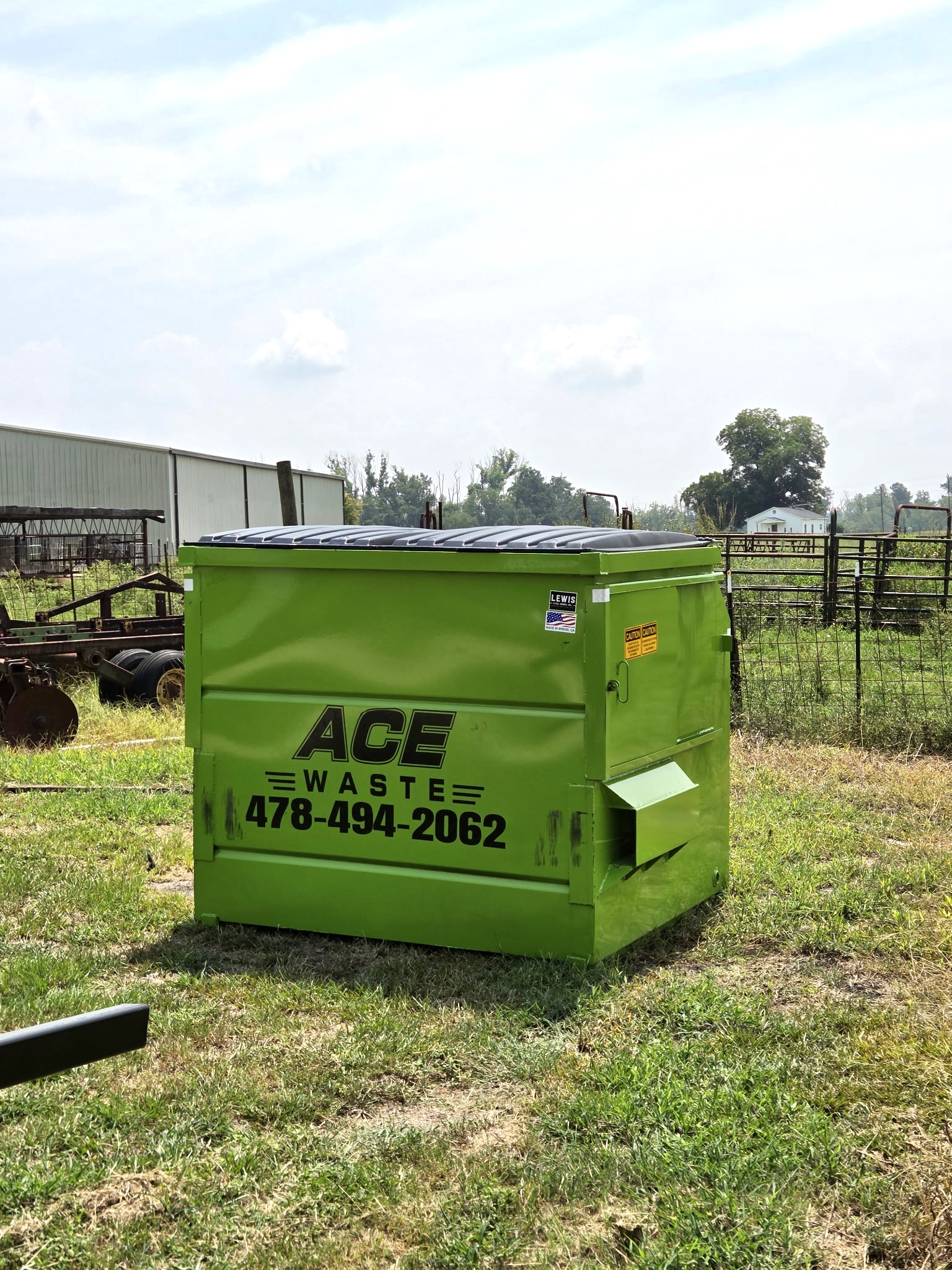 Green Ace Waste front-load dumpster with a closed lid