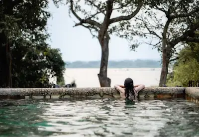 Woman relaxing in the pool with a view of the park in the background