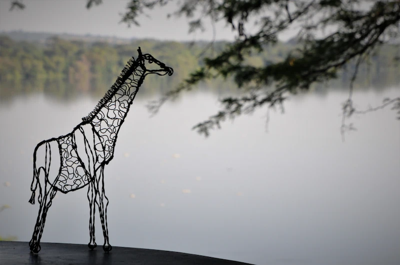 Wire giraffe made from snares found in Murchison Falls National Park in Uganda against backdrop of River Nile