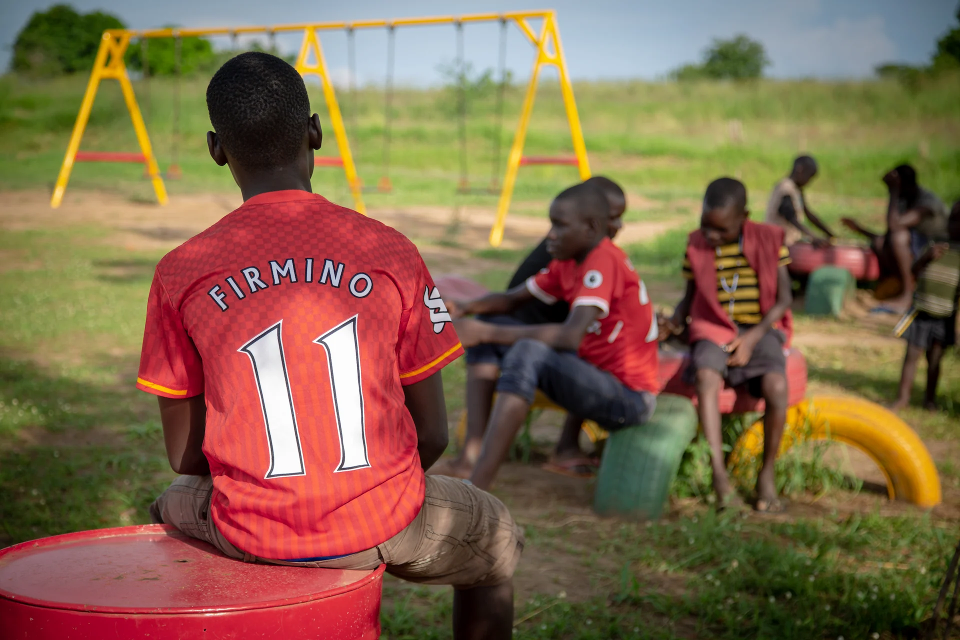 Children sitting on tyres in the community playground close to Murchison River Lodge 