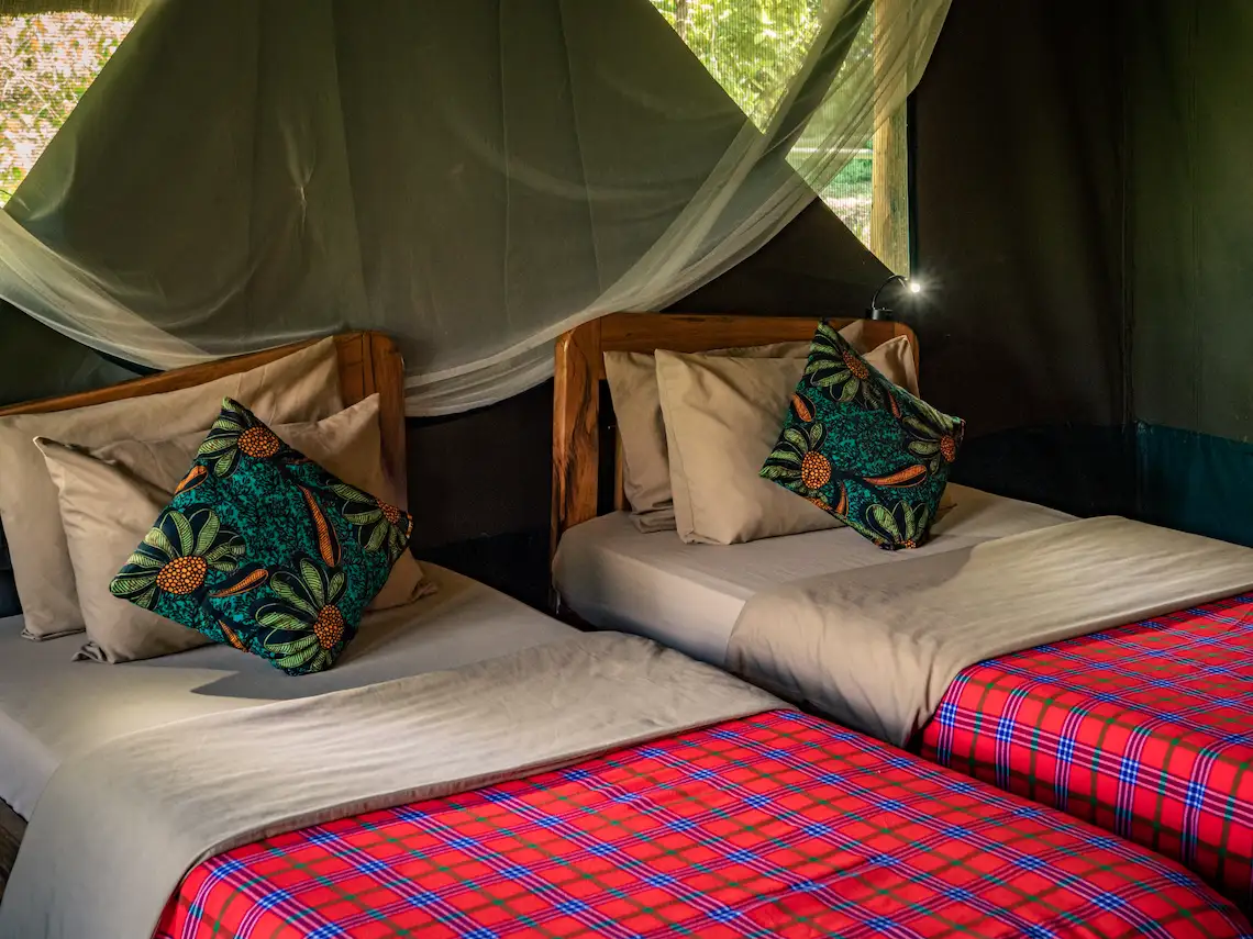 Interior of a Thatched River Tent, showcasing the beds and soft furnishings.
