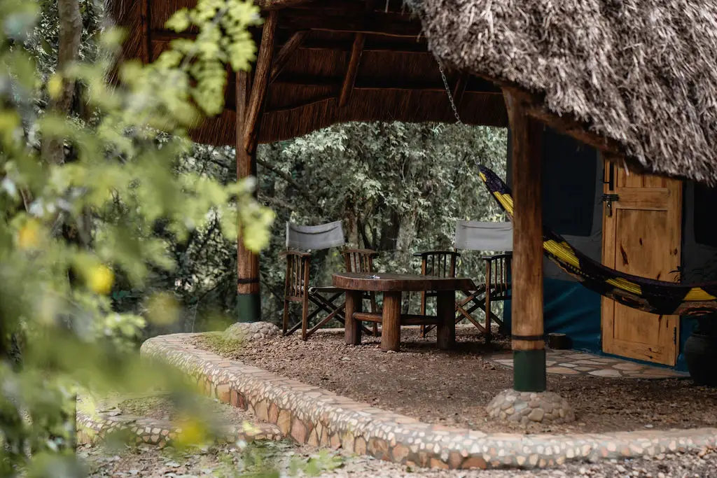 Thatched Safari Tent including the outside veranda with chairs offering a view of the bush and surrounding grounds 
