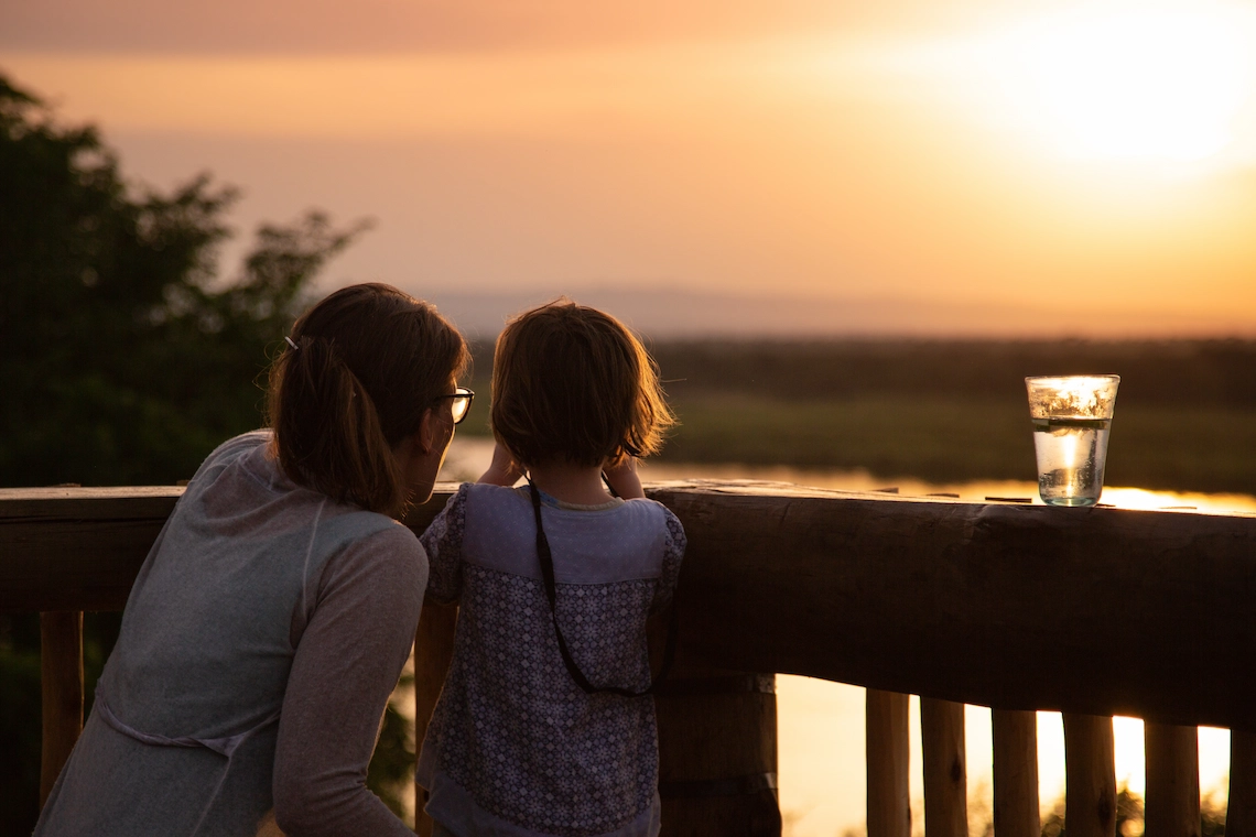 Mother and daughter on the viewing platform watching the sun setting over the River Nile