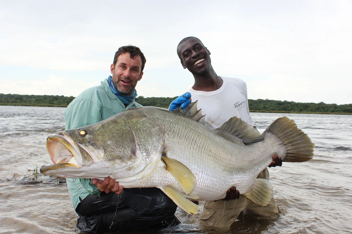 Fisherwoman holding a Nile Perch on the River Nile in Murchison Falls National Park, Uganda 