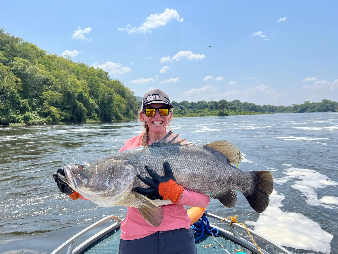 Holding a Nile Perch on the River Nile in Murchison Falls National Park Uganda 