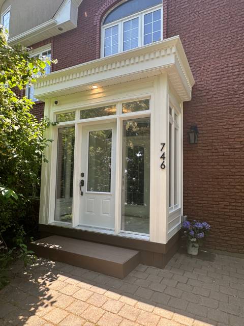 Bump-out home extension with a glass vestibule entry on a brick townhome