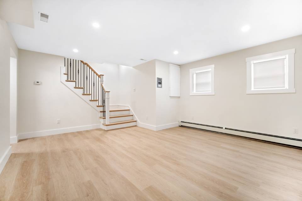 Renovated basement rec room with laminate flooring and a bright open layout