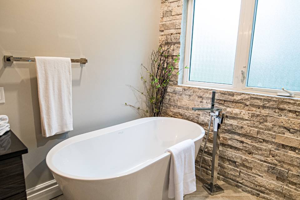 Bathroom renovation with a freestanding tub and full-height tile