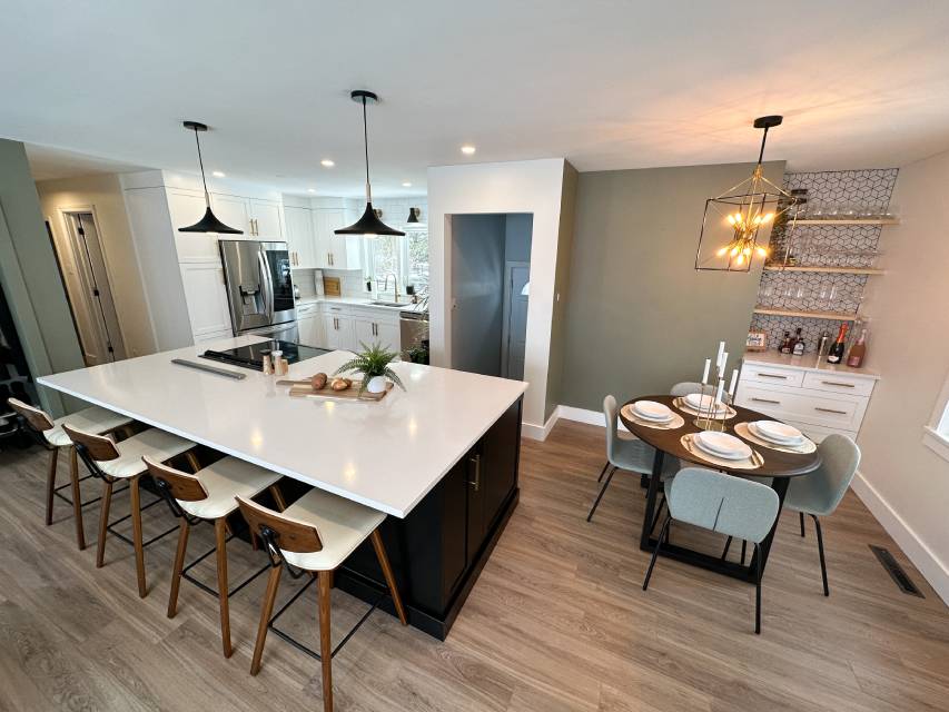 Kitchen renovation with dark lower cabinets and a tiled backsplash