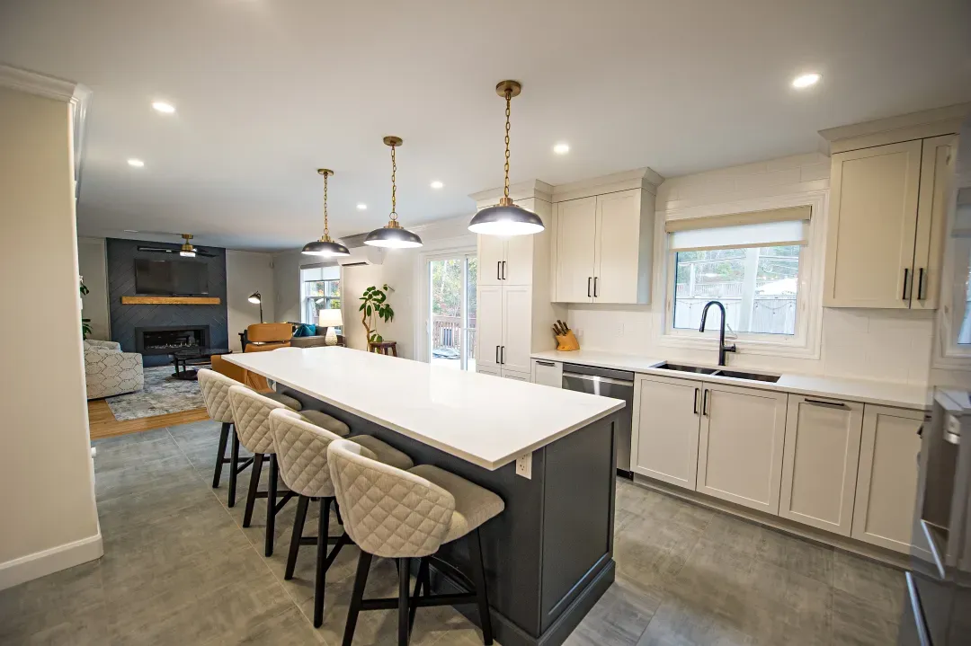 Fall River whole home remodel kitchen with a dark island, white cabinets and pendant lights