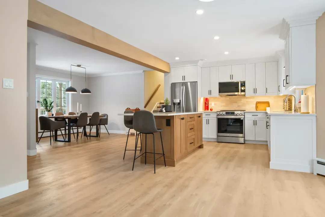 Open concept kitchen and dining room in Hammonds Plains with white cabinets and island seating