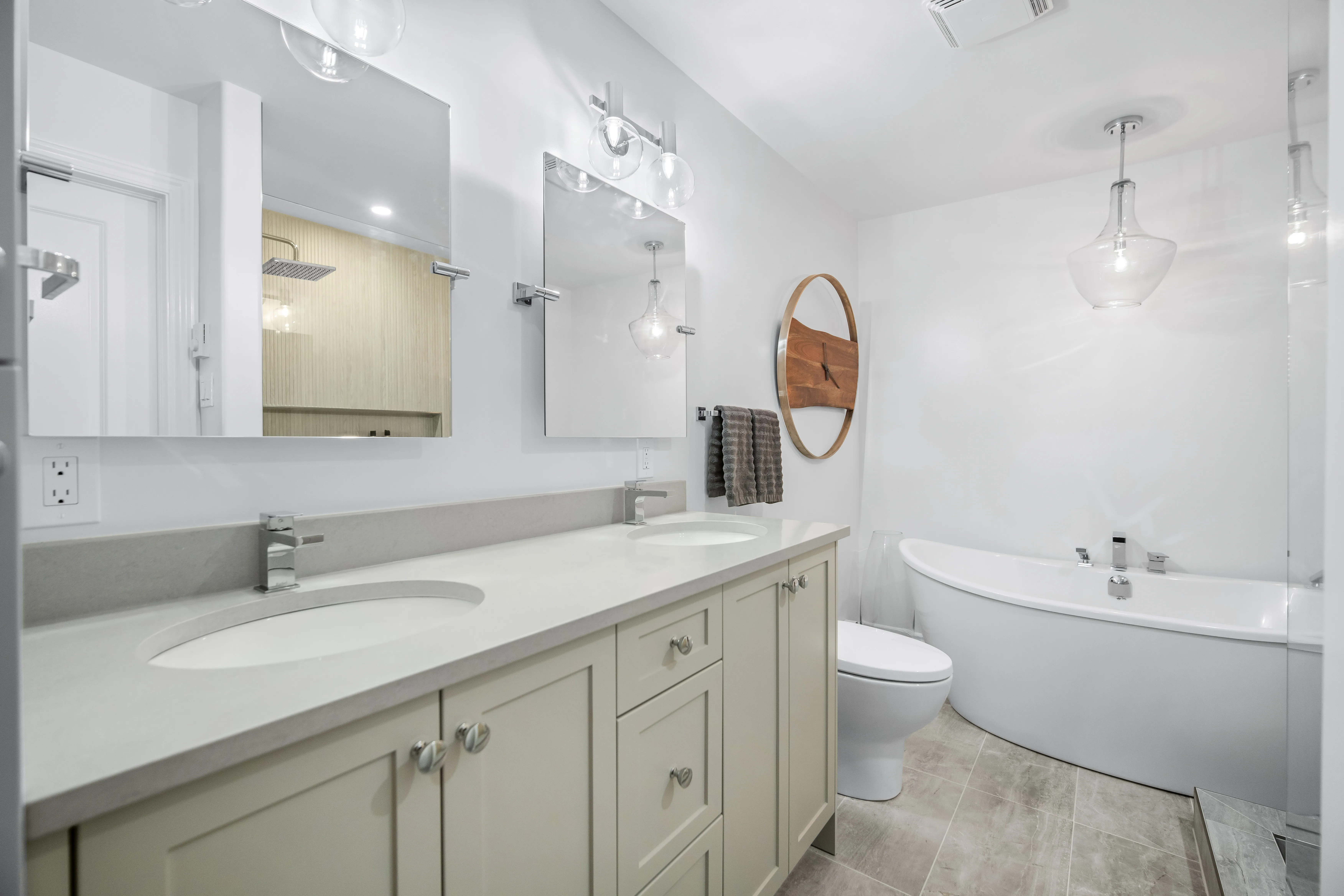 Long ensuite with a sage double vanity and a soaker tub at the far end
