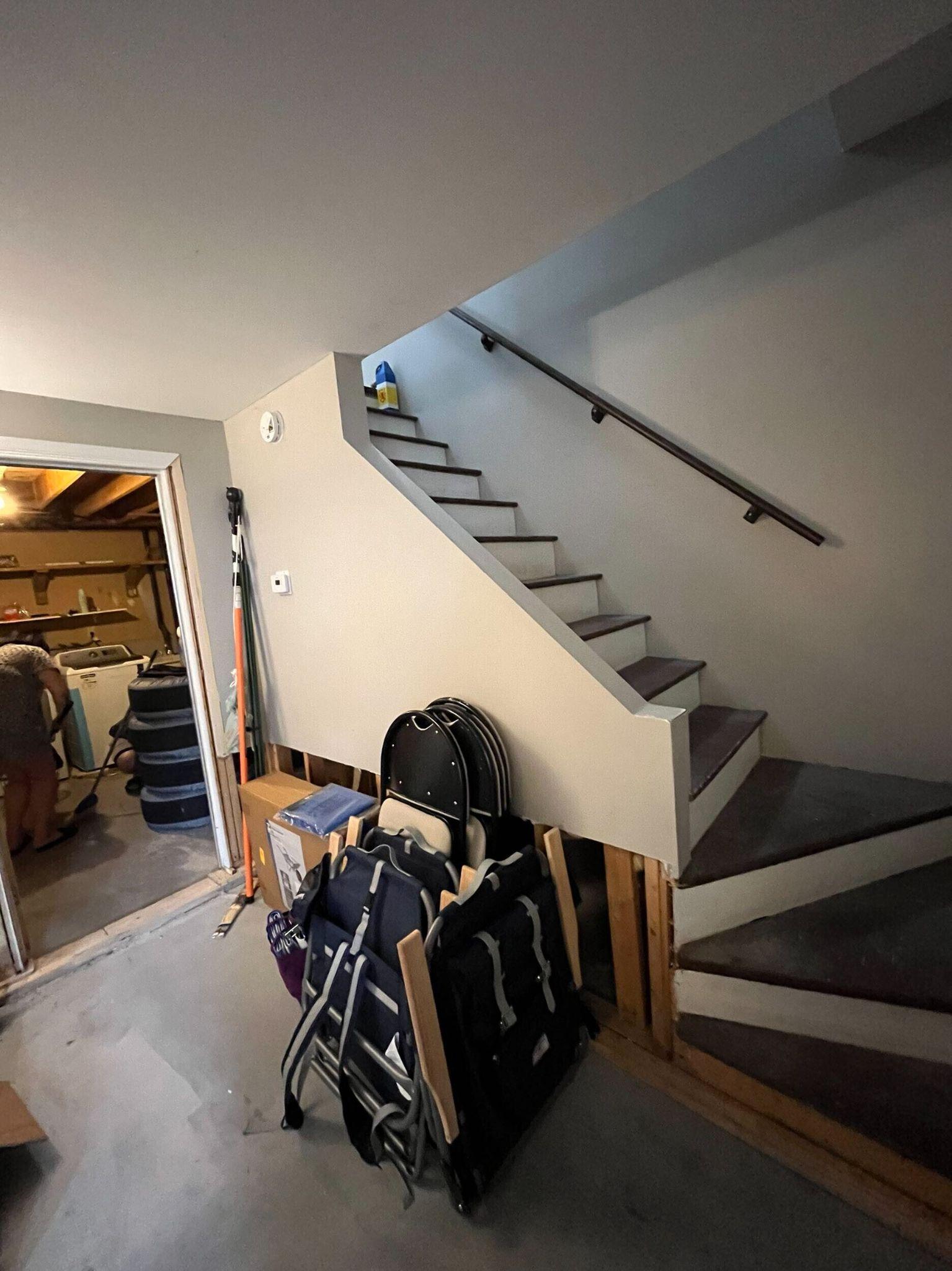 Basement apartment laundry room with a full-size washer and dryer and marble-look tile floor
