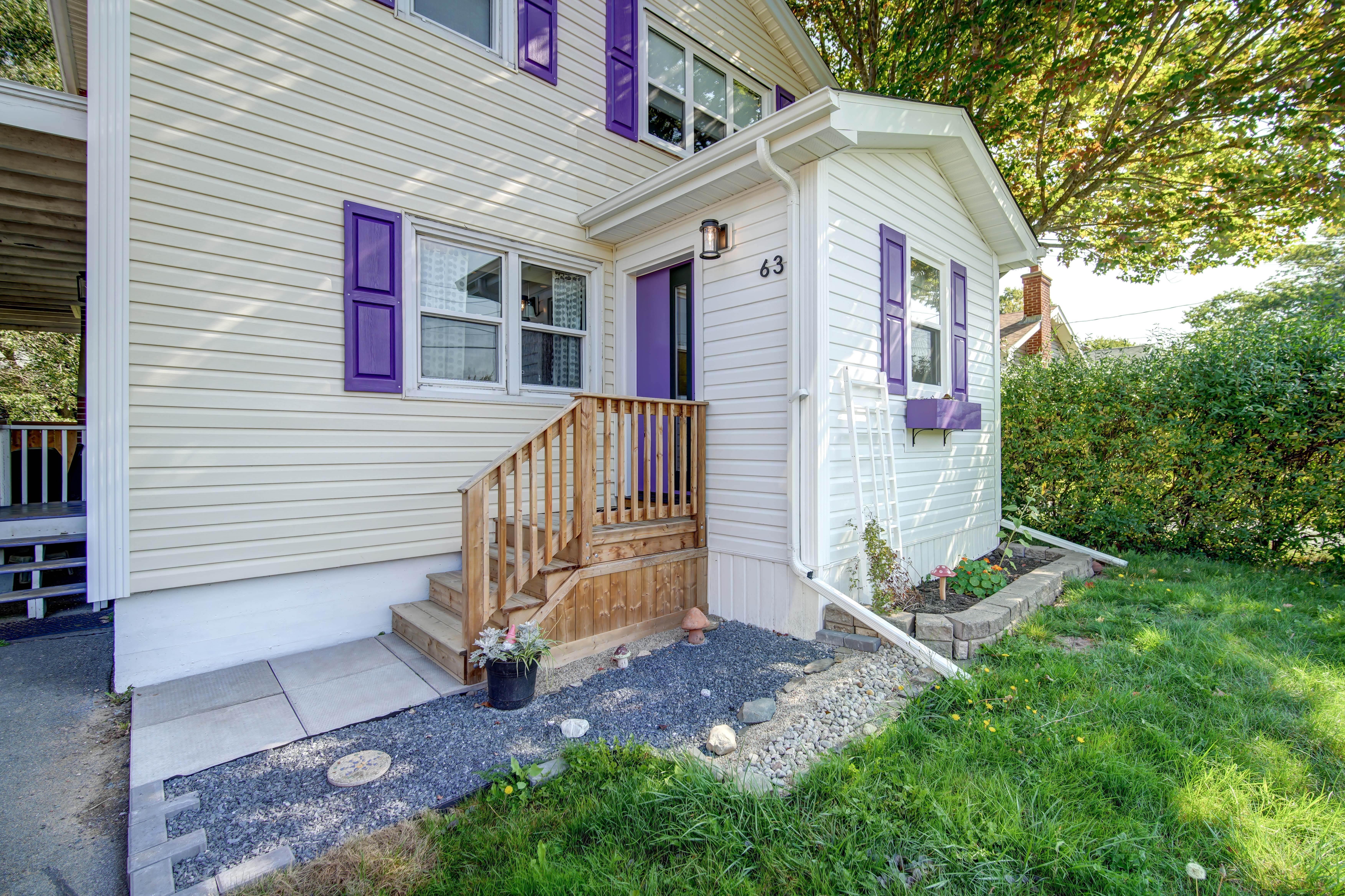 Front elevation of a Dartmouth home after its addition, with white siding and rebuilt front steps