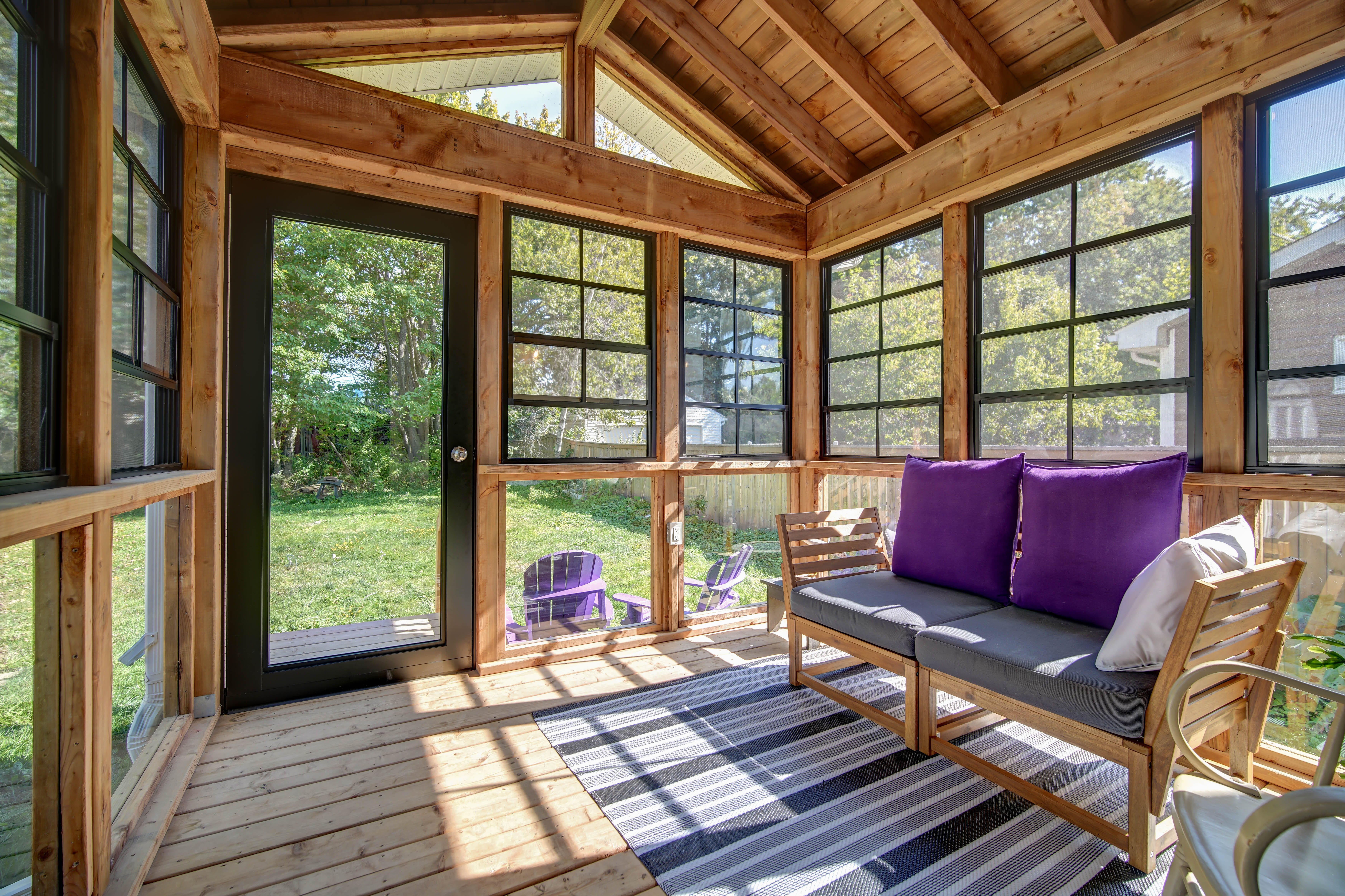 Four-season room addition in Dartmouth glazed on three sides under an exposed timber roof