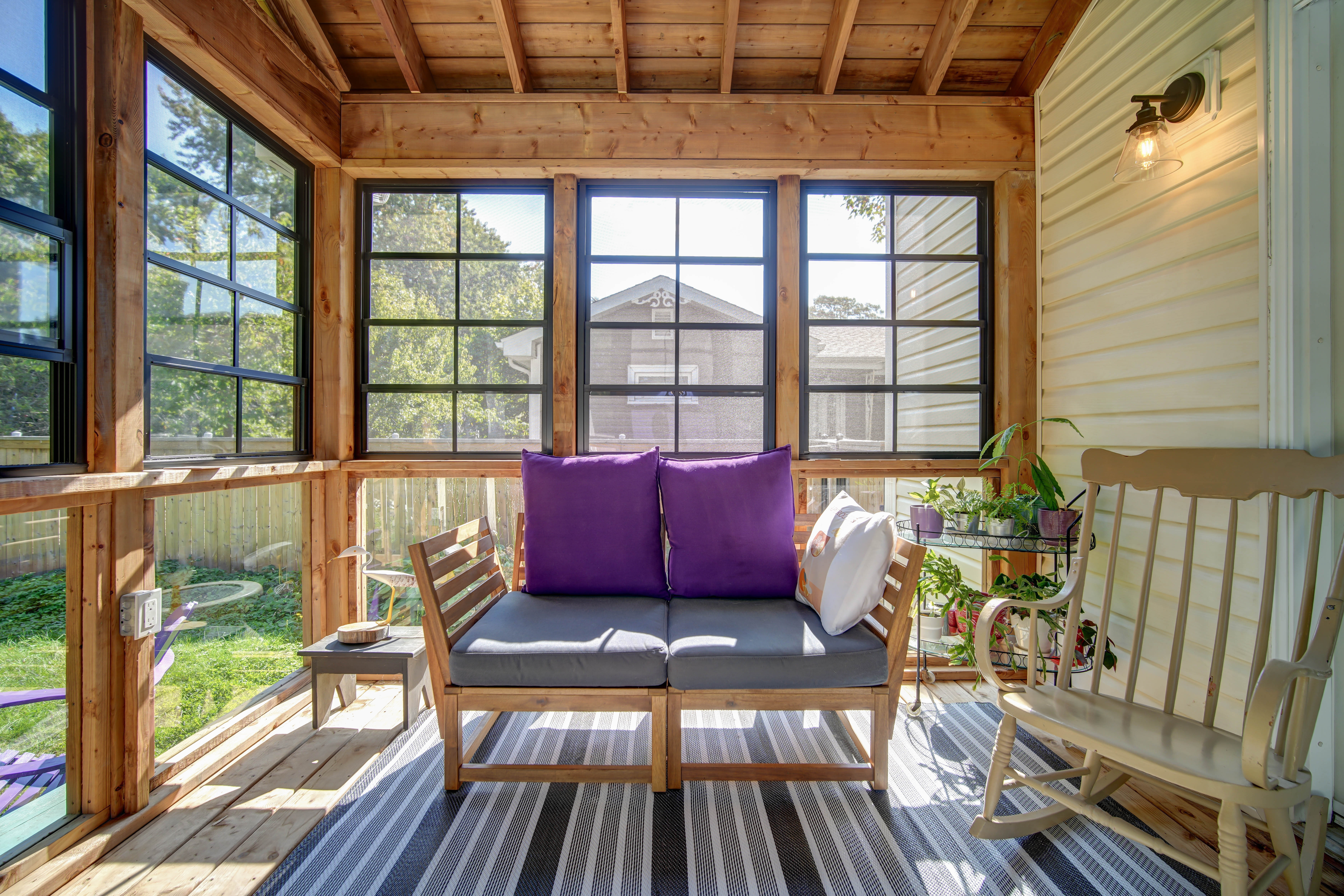 Seating area inside a Dartmouth four-season room addition with afternoon light across the deck