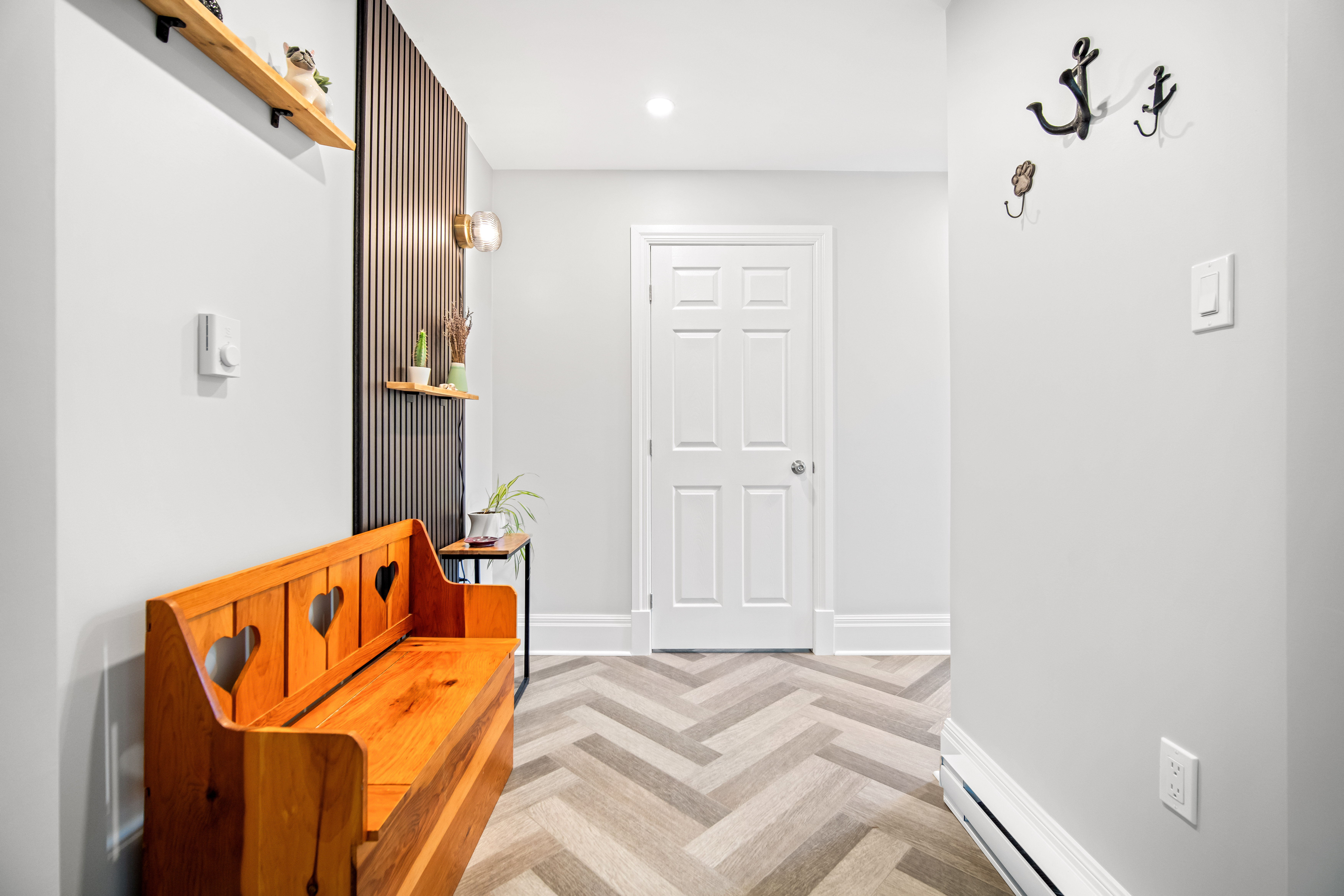 Mudroom built in a Dartmouth addition with a slat feature wall and a pine bench