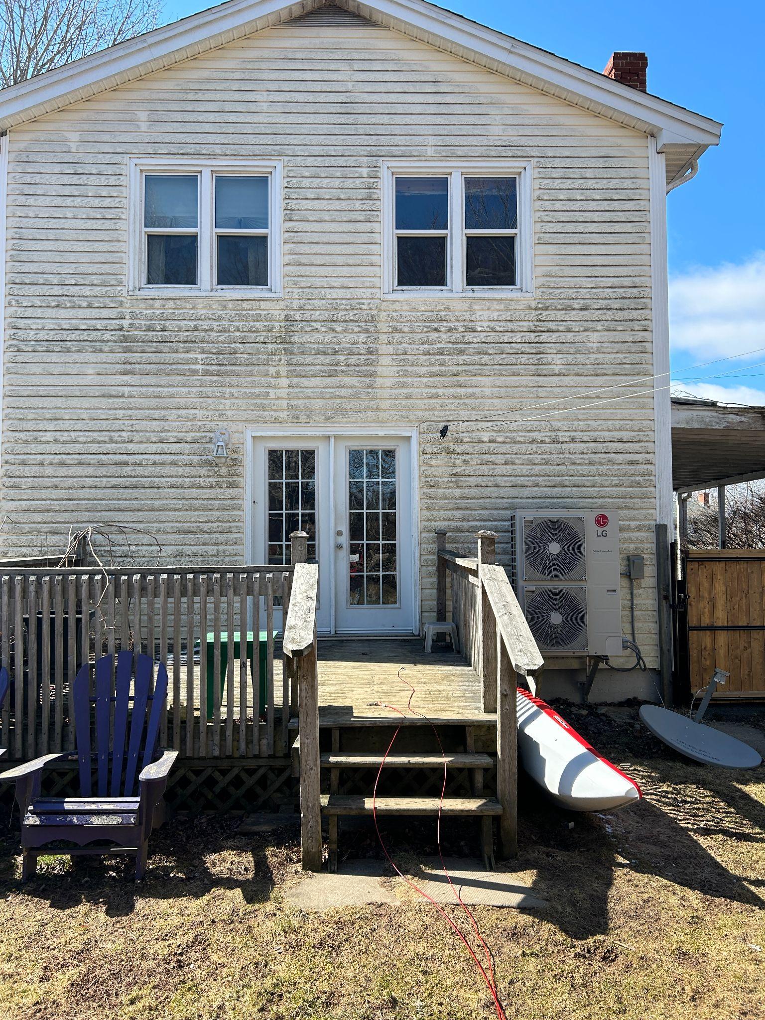 Rear elevation of a Dartmouth house before its addition, with the original siding, old deck and heat pump on grade
