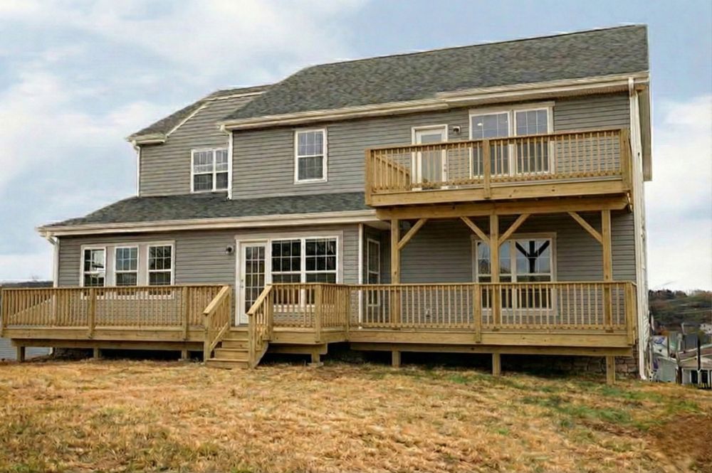 Rebuilt two-level wood deck with railings and stairs on a two-storey home
