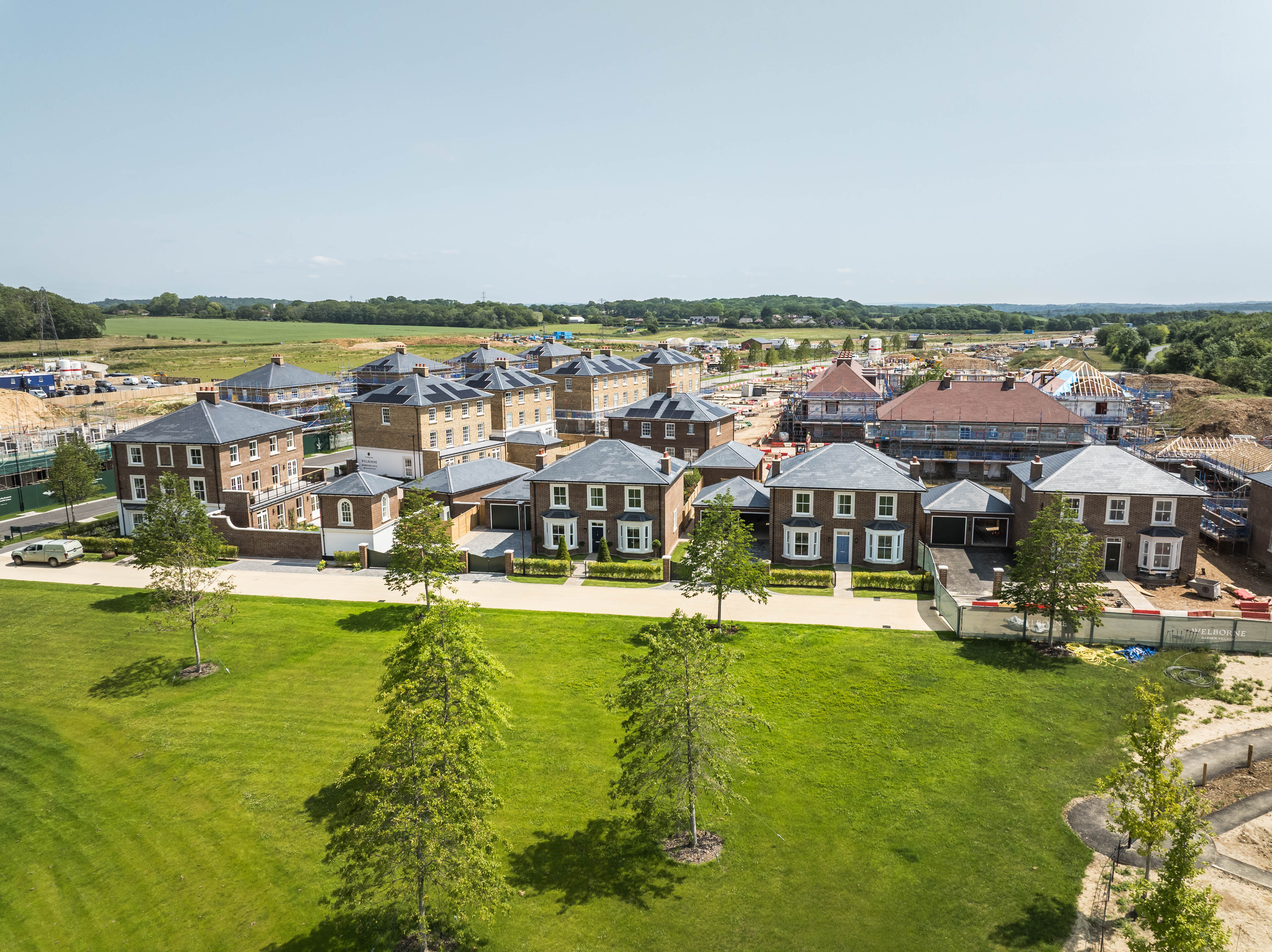 Aerial view of new housing development with green lawn and construction site