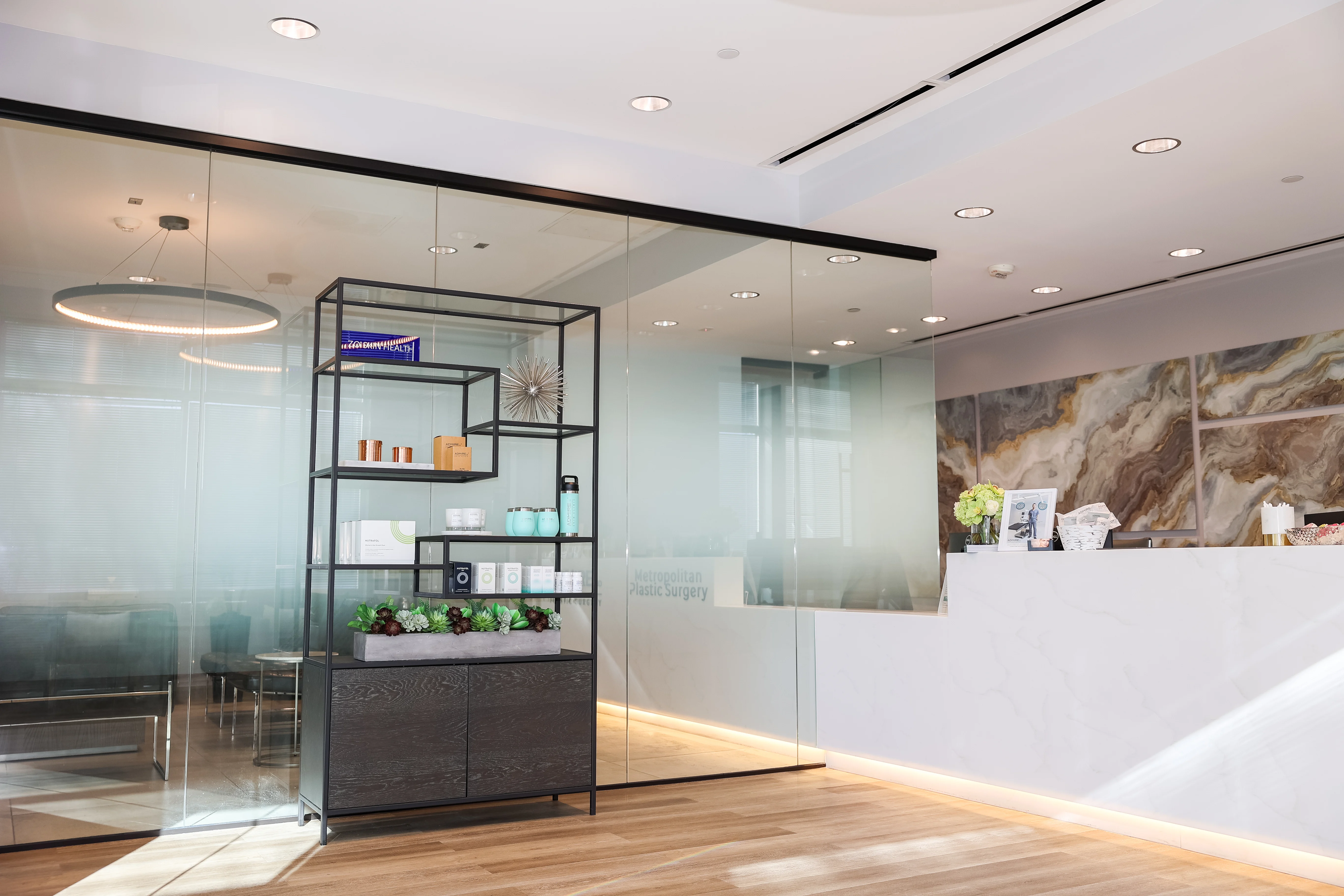 Bright modern reception area at Metropolitan Plastic Surgery Scottsdale office, with retail skincare display and waiting area.