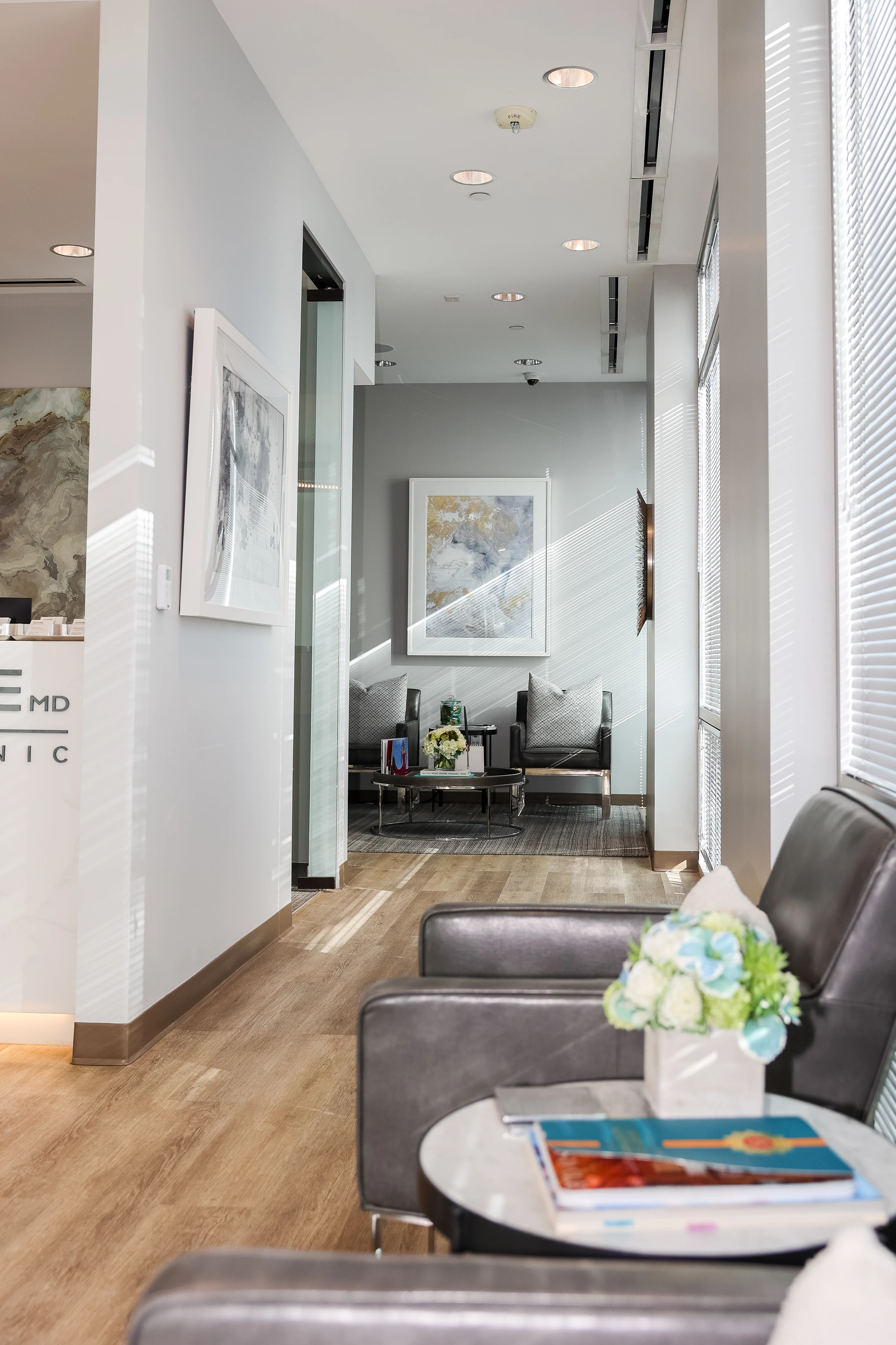 Bright, modern waiting area at Metropolitan Plastic Surgery in Scottsdale with comfortable chairs, floral decor, and wall art.