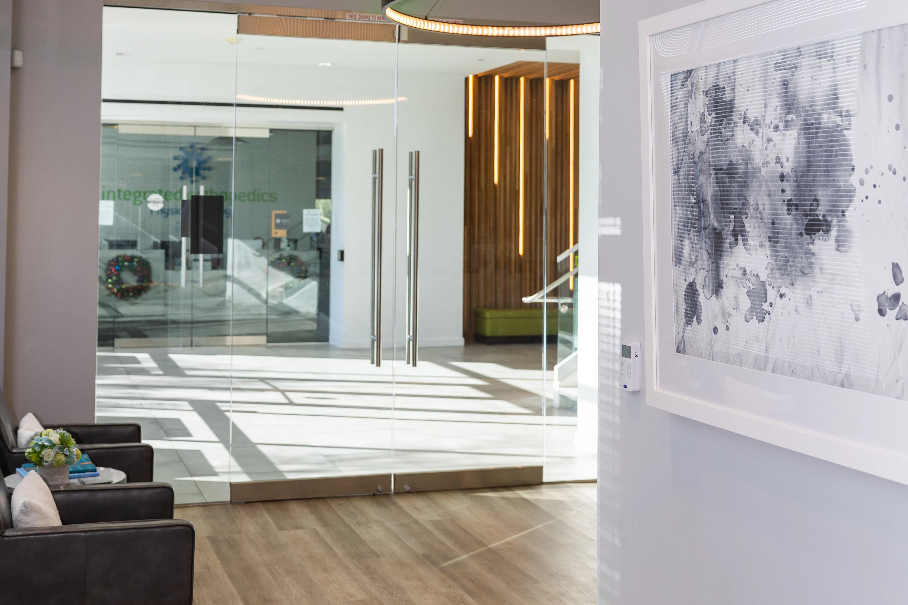Lobby seating area with modern chairs and art at Metropolitan Plastic Surgery Scottsdale office, with glass doors and natural light.