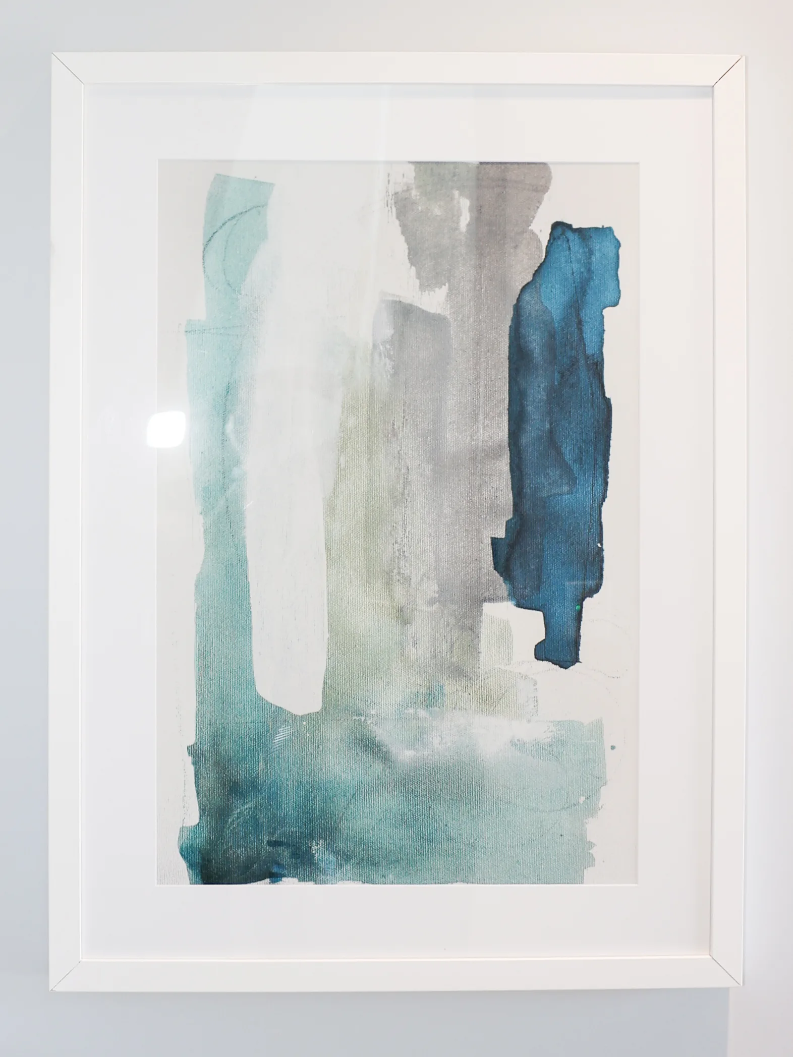 Framed teal and gray abstract painting on clean white wall at Metropolitan Plastic Surgery, Scottsdale location.