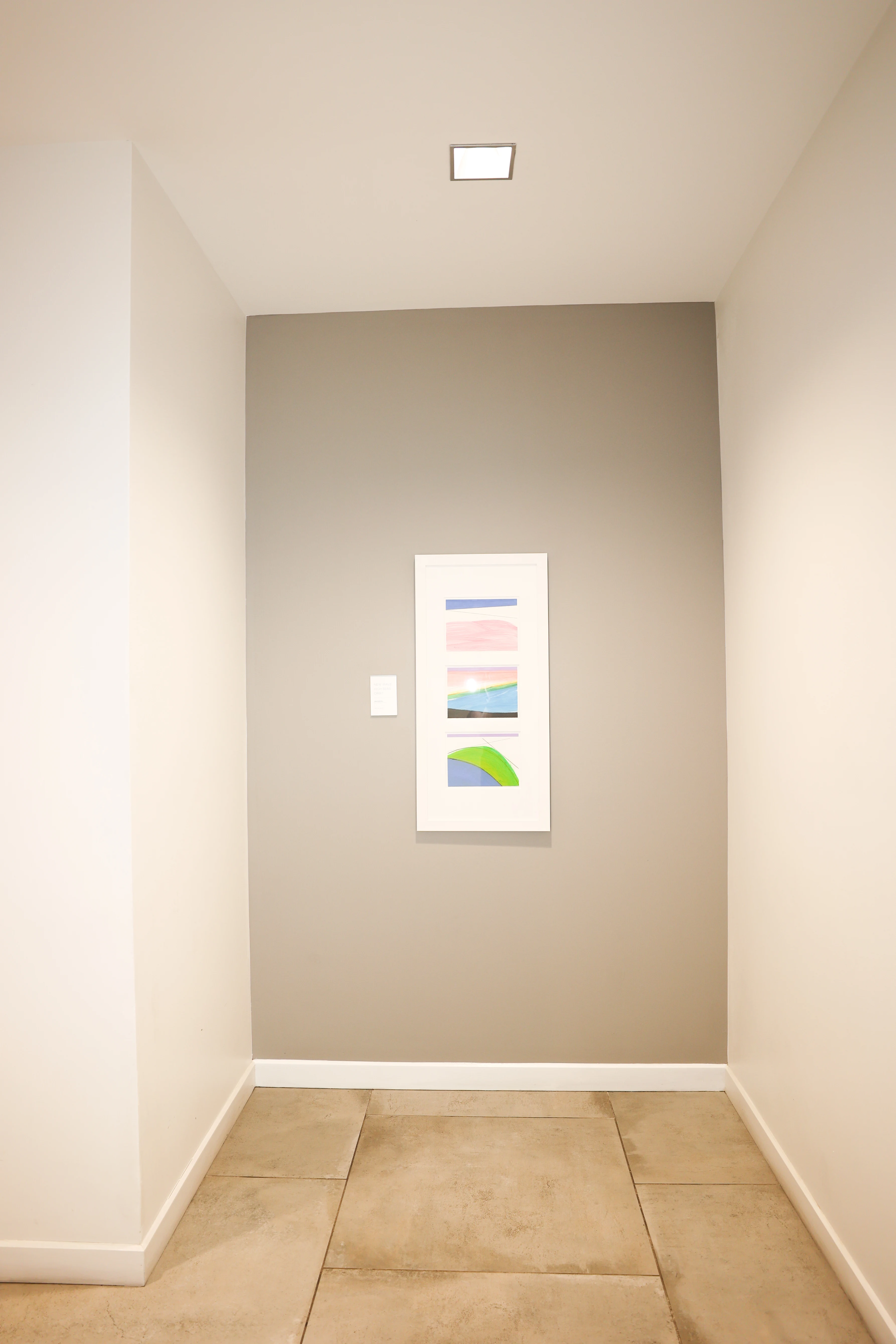 Clean hallway with tile flooring and framed colorful modern art at Metropolitan Plastic Surgery Scottsdale office building.