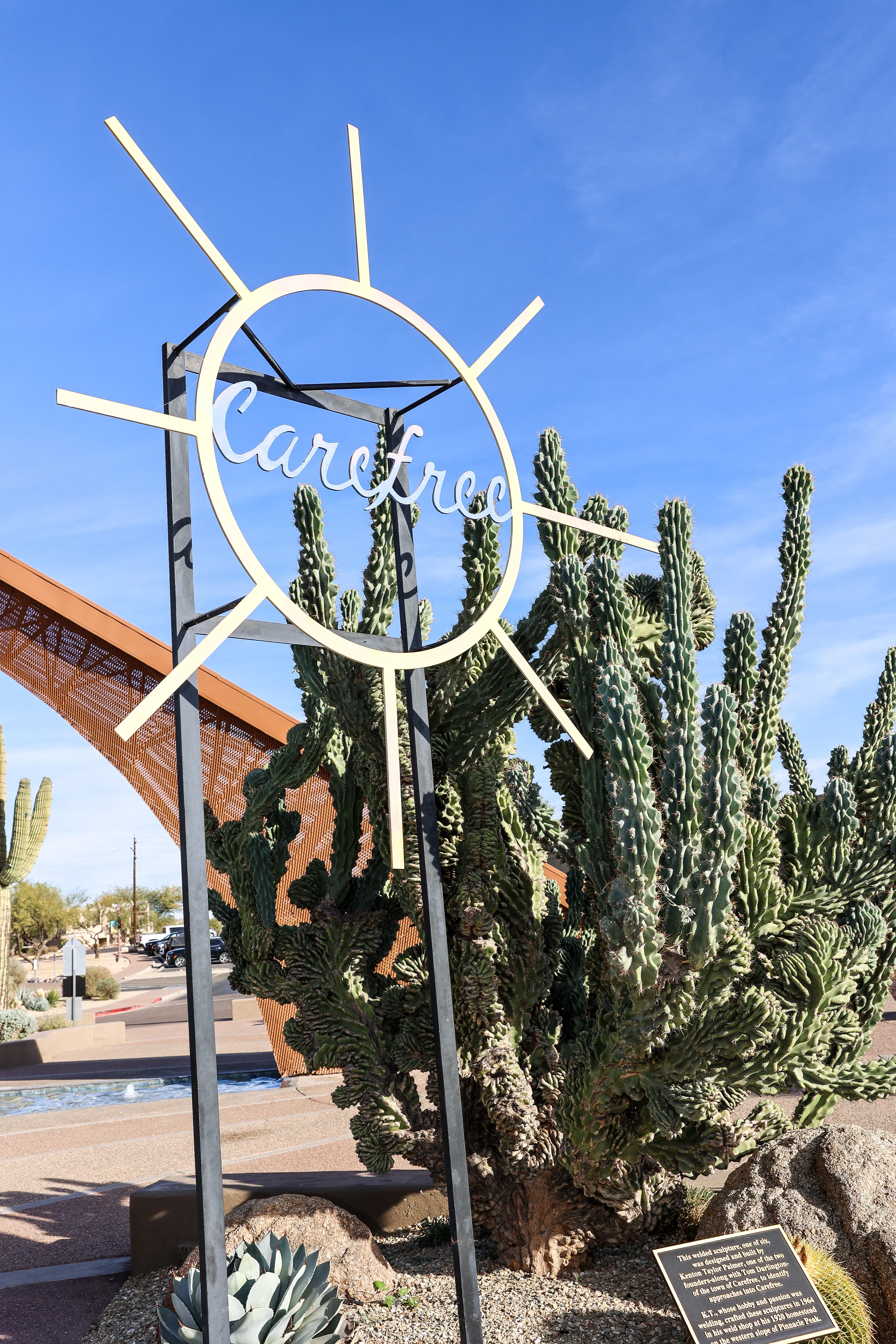 Iconic Carefree Arizona sign surrounded by desert cacti and sunny blue sky near Metropolitan Plastic Surgery’s Carefree location.