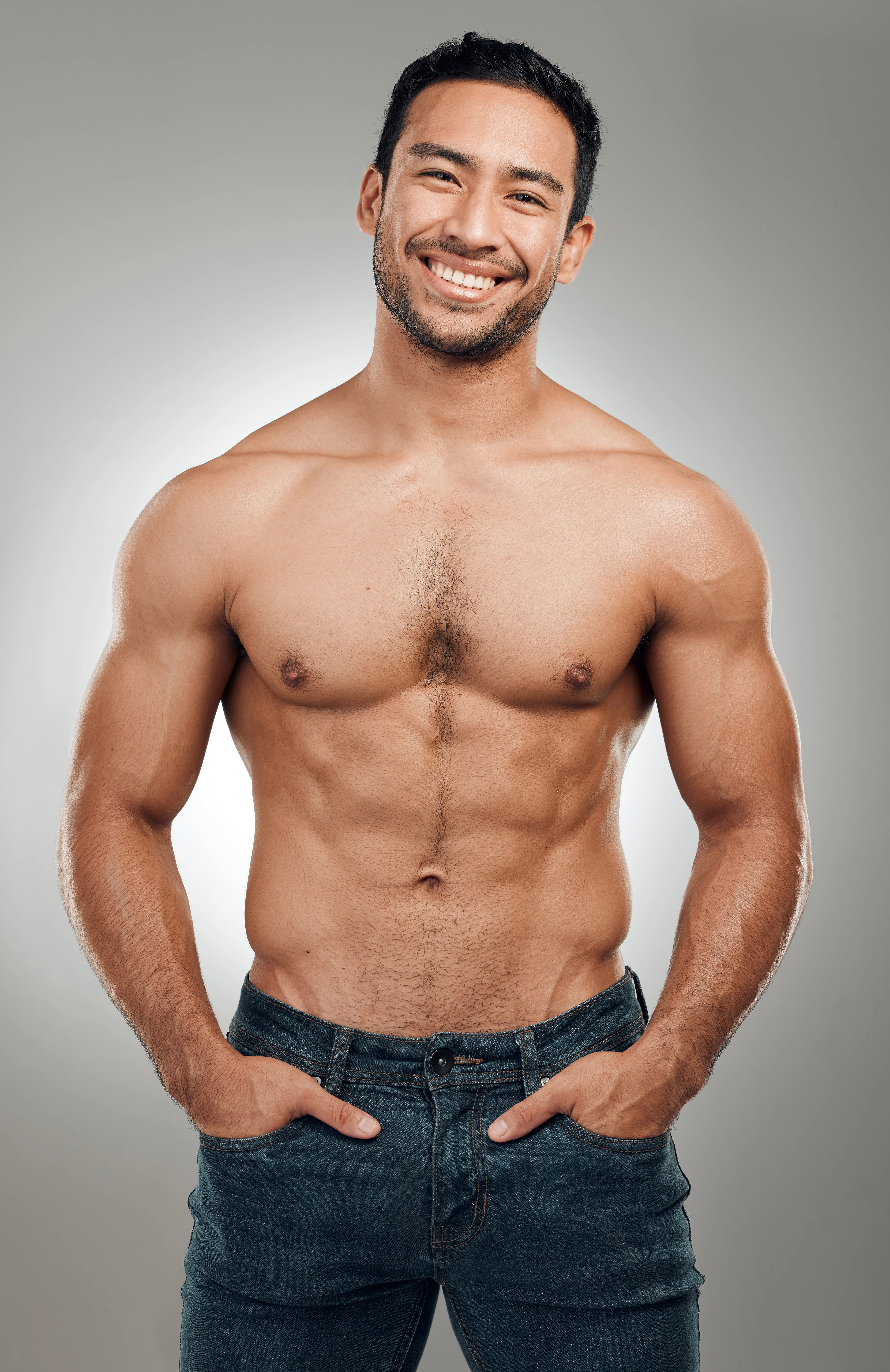 Fit, shirtless man smiling confidently after body contouring procedure