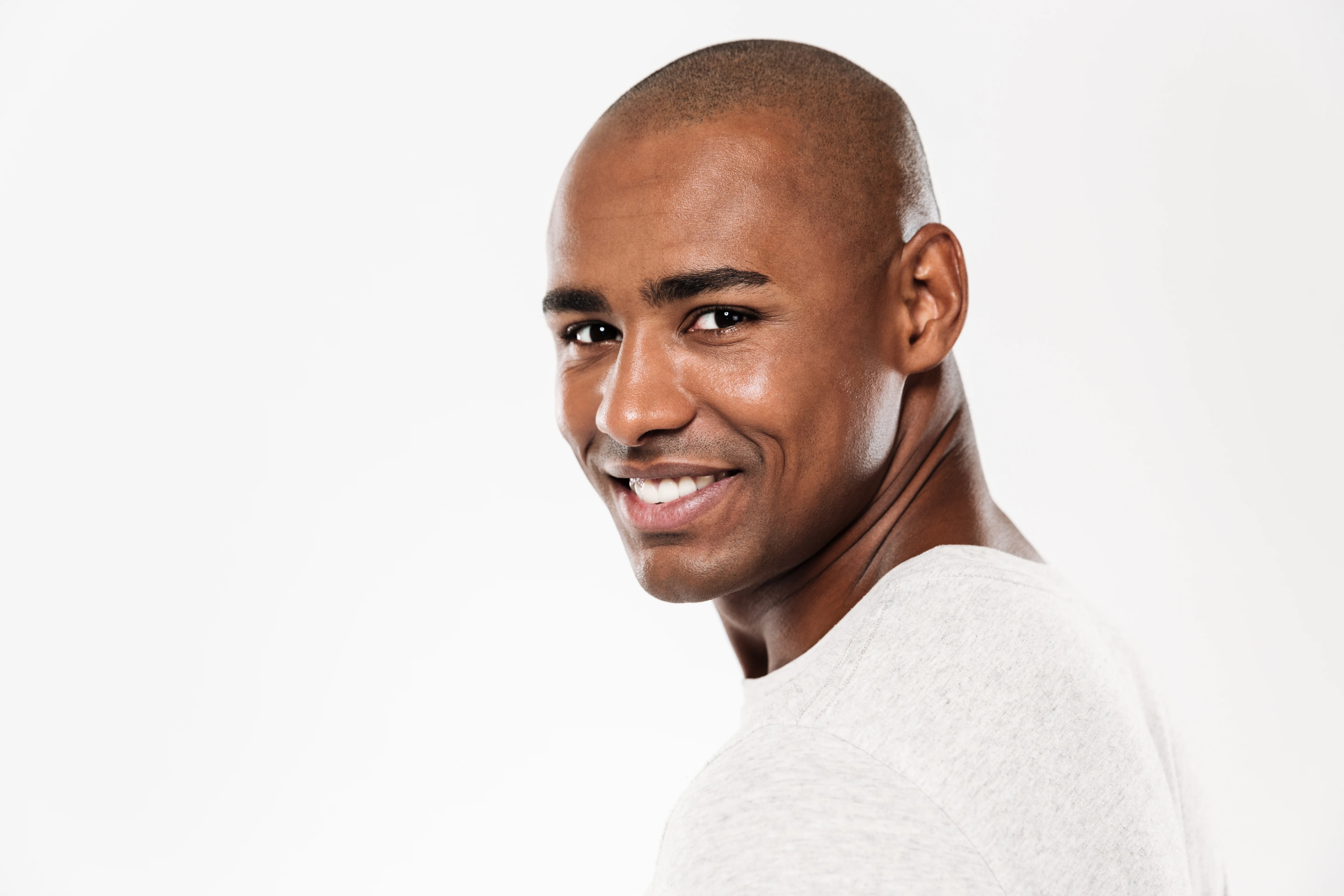 Confident Black man smiling after face and neck rejuvenation treatment.