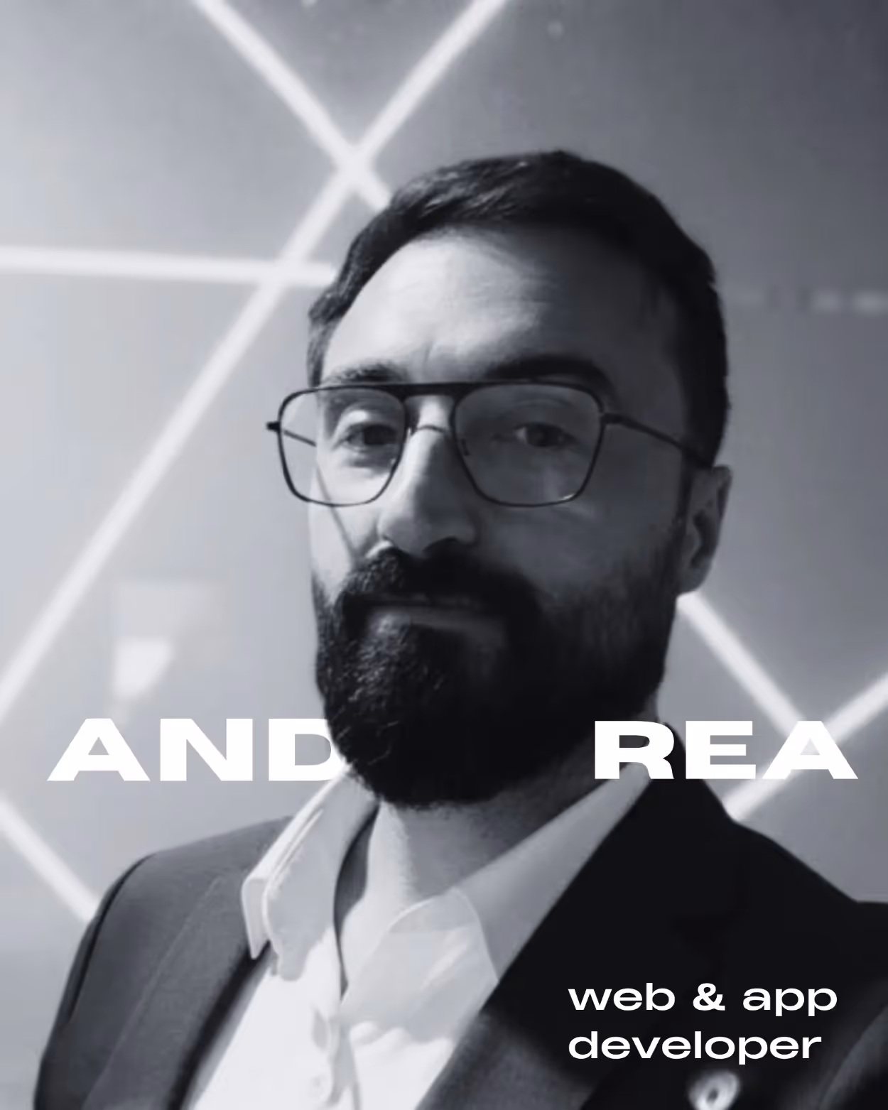 Ritratto in bianco e nero di un uomo con barba e occhiali, vestito con camicia bianca e giacca scura, con sfondo geometrico e testo 'web & app developer'.