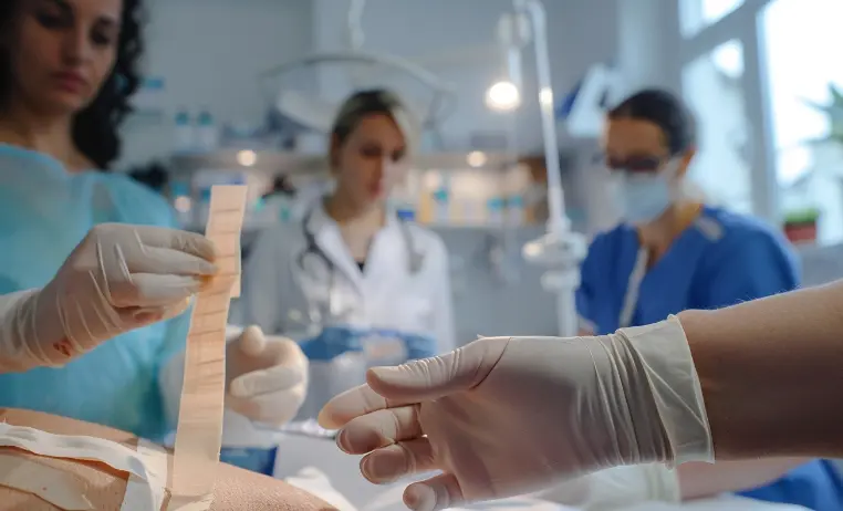 An image showing doctors inside a clinic applying Xeroform dressing strips on a patient.