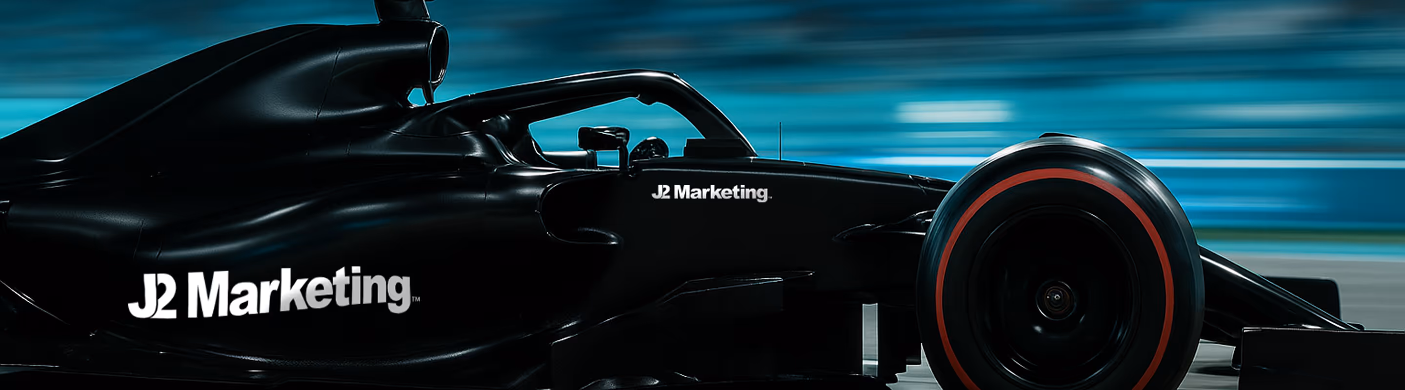 An f1 racecar branded with J2 Marketing