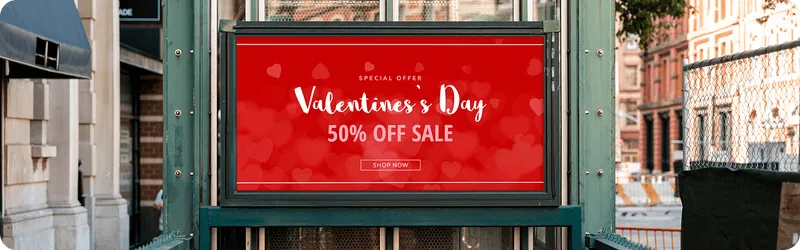 A red valentine's day sale sign on the side of a building.