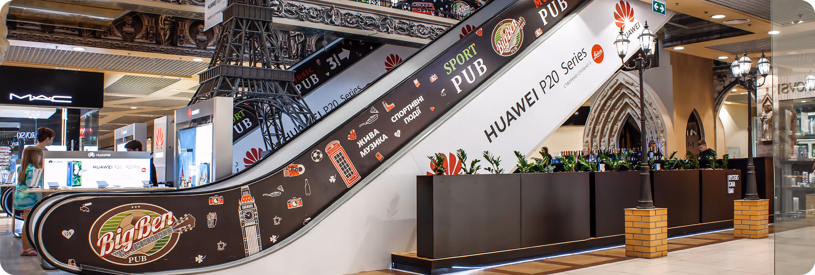 An escalator in a mall with a bunch of signs on it.