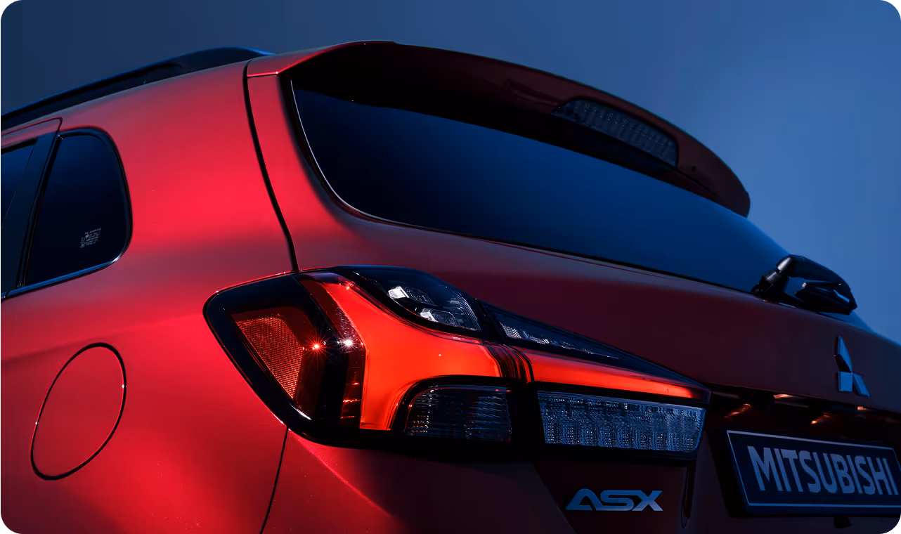 A close up of the tail lights of a red car.