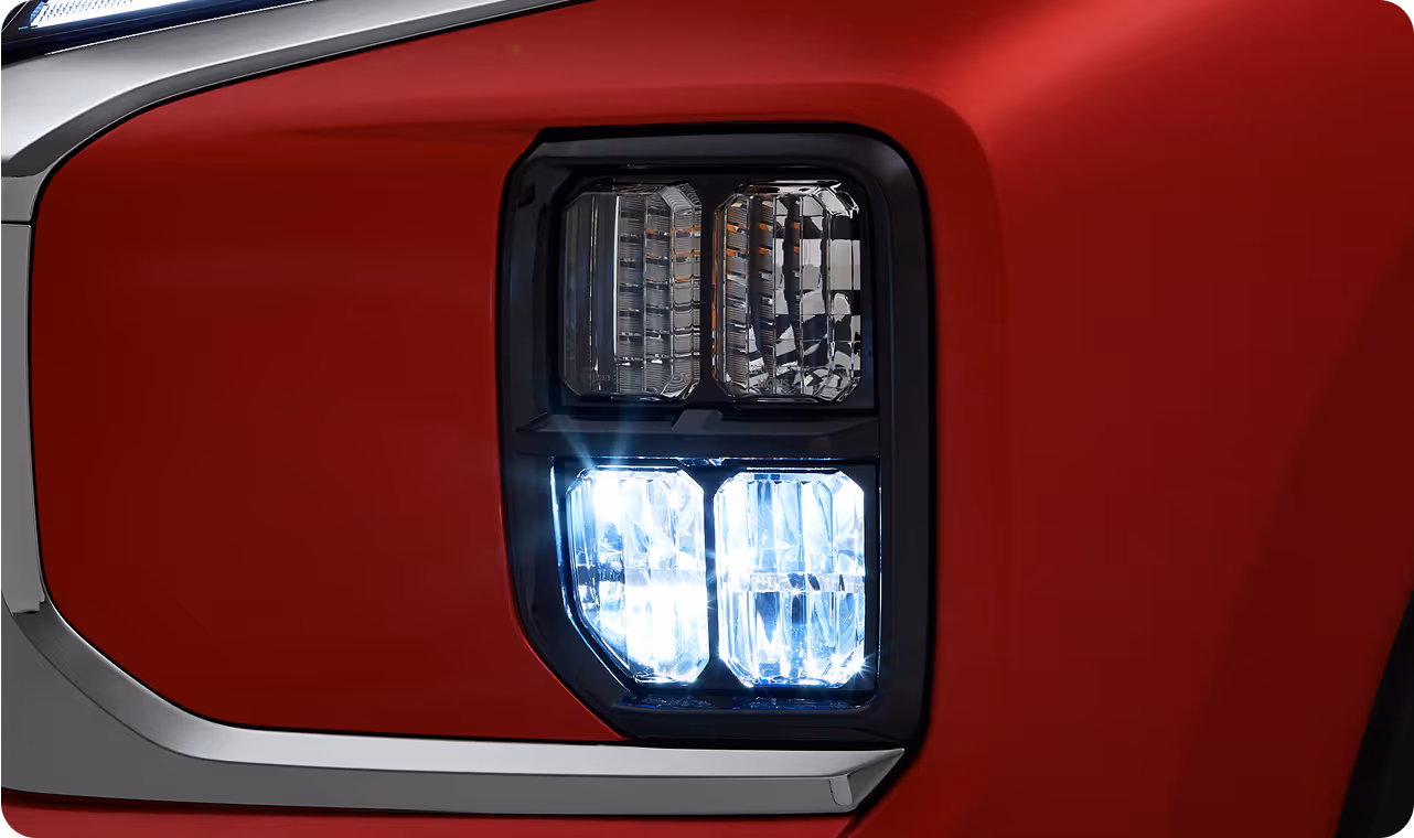 A close up of a red truck's headlight.