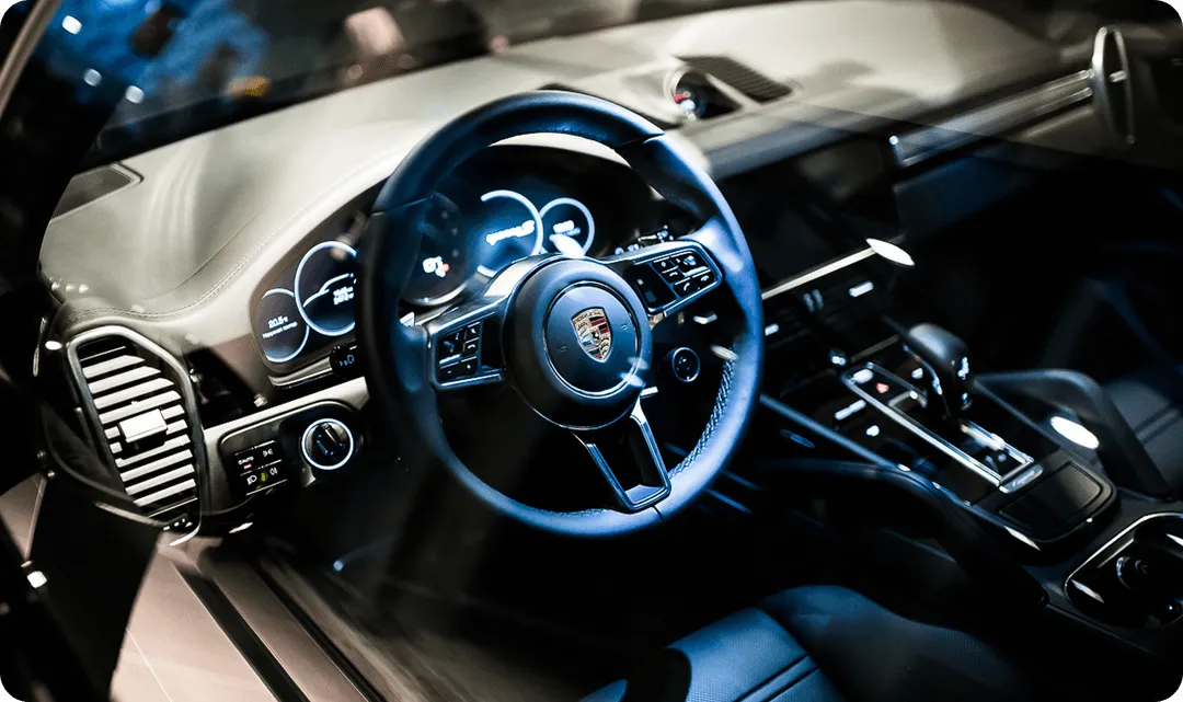 The interior of a car with a steering wheel and dashboard.