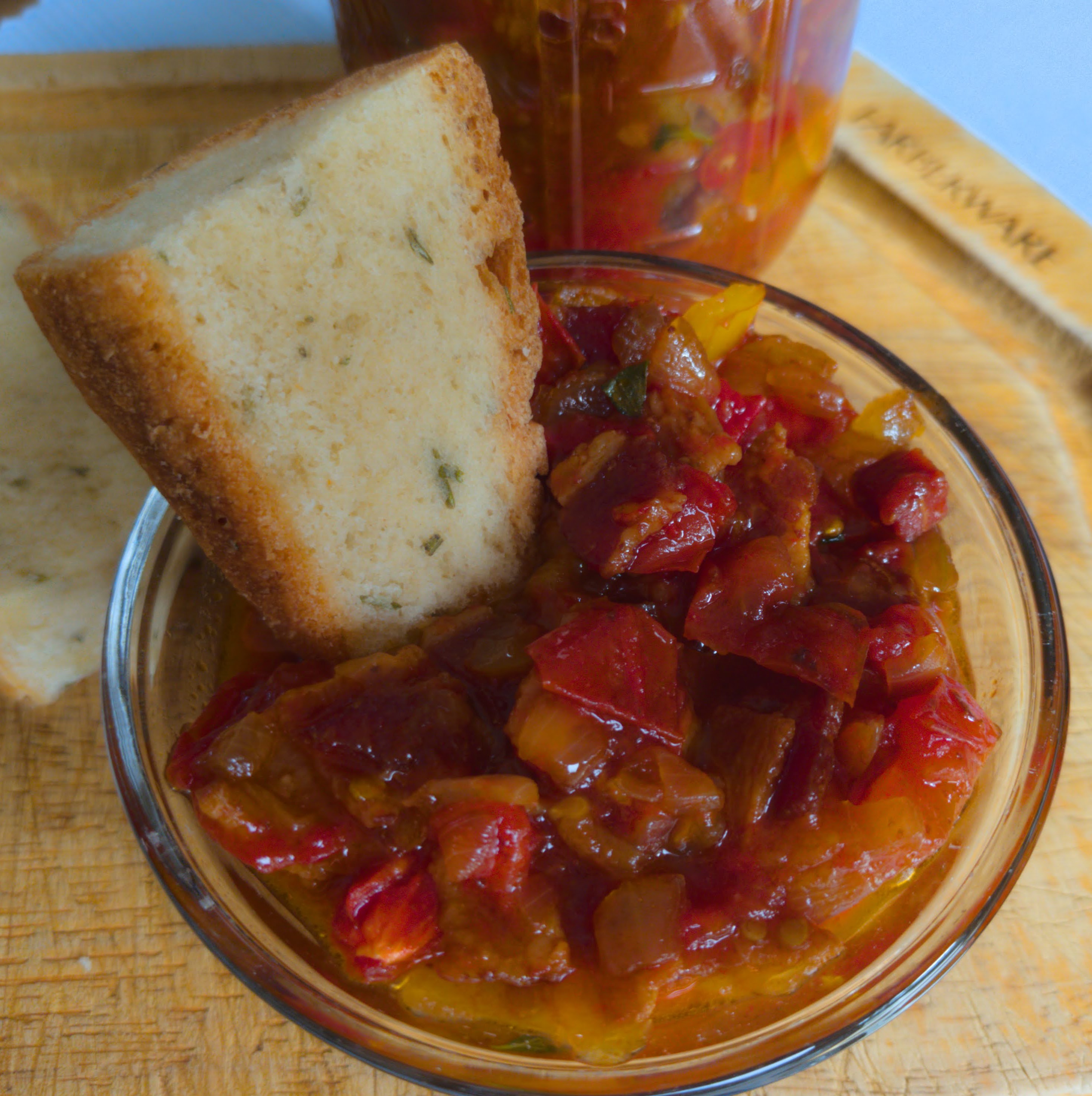 Crusty bread dipped into Bourbon Bacon Tomato Jam