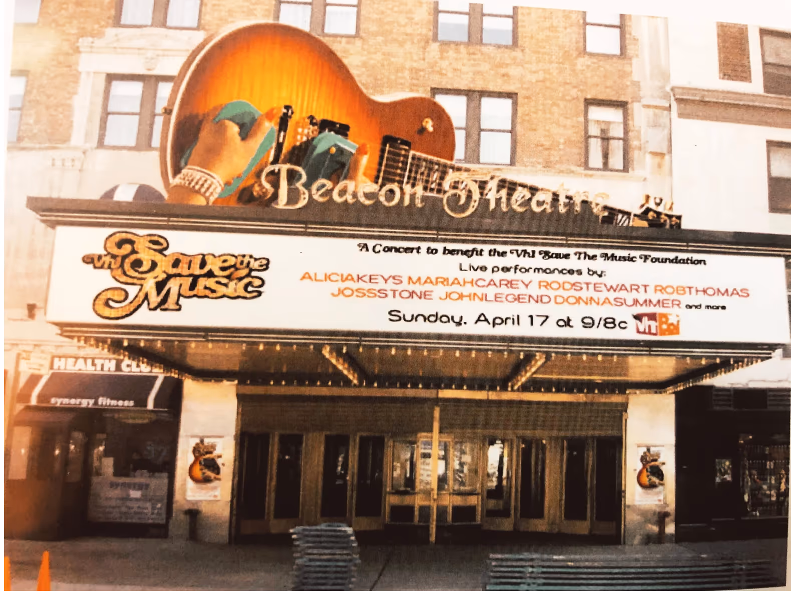 Photograph of the Beacon Theatre marquee promoting the VH1 Save The Music Concert, a star-studded event to benefit music education, including live performances by top artists Mariah Carey, Alicia Keys, John Legend, Rob Thomas, Joss Stone, and Rod Stewart. Designed  by Myriam López