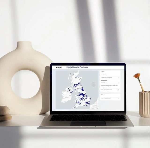 Laptop on desk displaying the Mapping Advertising Assets Project (MAAP) Leeds website, surrounded by a gold lamp, books, glasses, and a cup on a saucer.