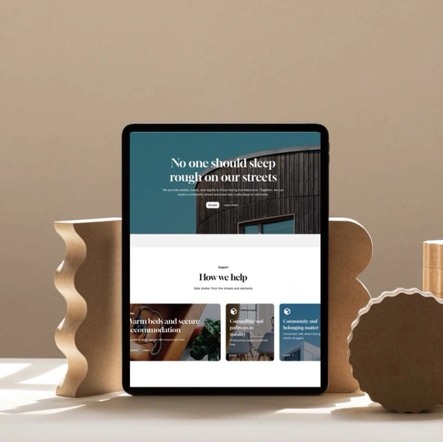 Desktop computer on a wooden desk displaying the Welcome page of the Carbon Footprint Calculator website with instructions and menu options.